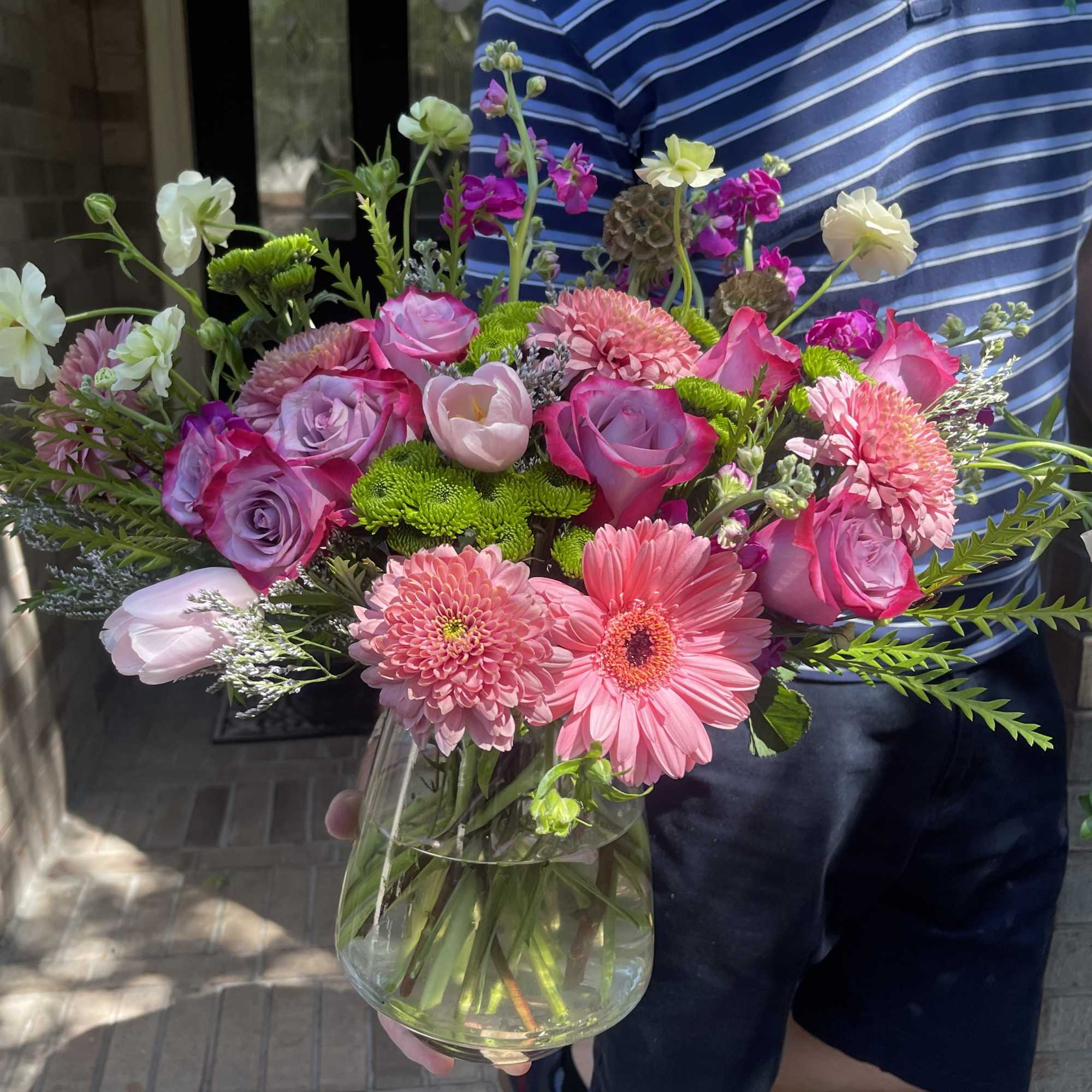 Mixed pink and white flowers arranged in a clear glass vase