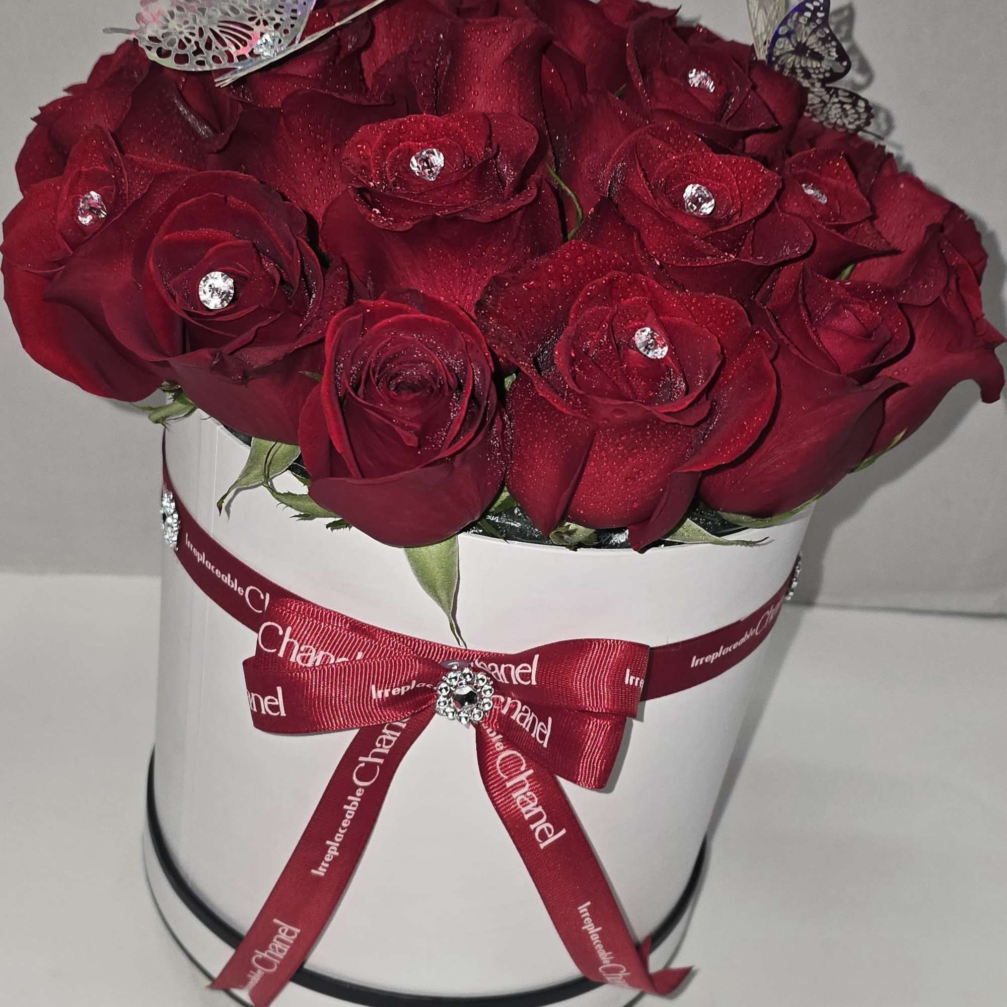 Red rose bouquet in a white hat box with a ribbon bow
