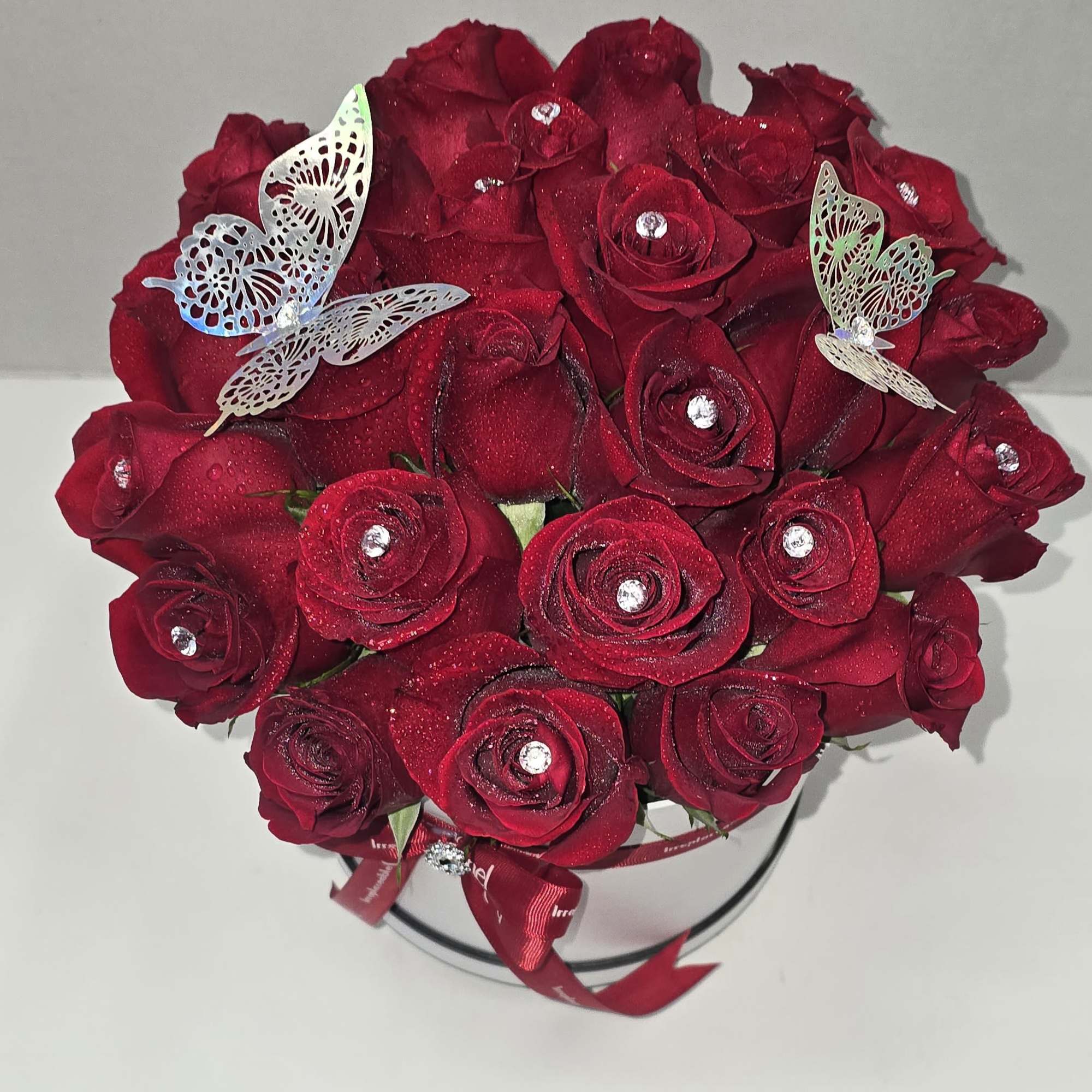 Bouquet of red roses with butterfly decorations in a round box