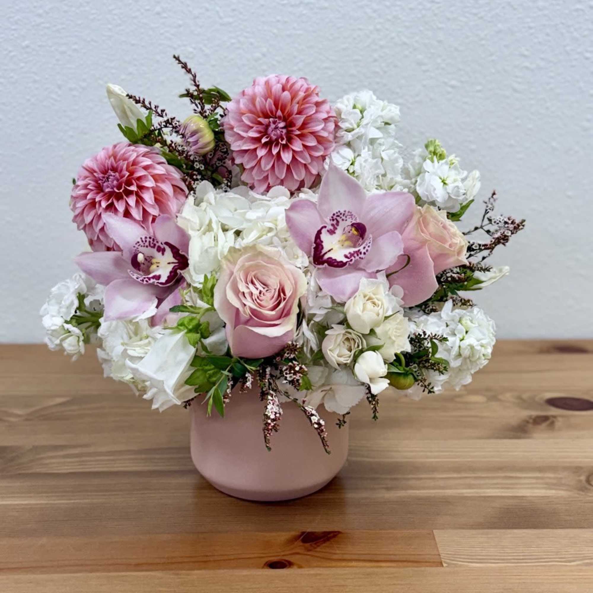 Pink and white floral arrangement in a blush vase