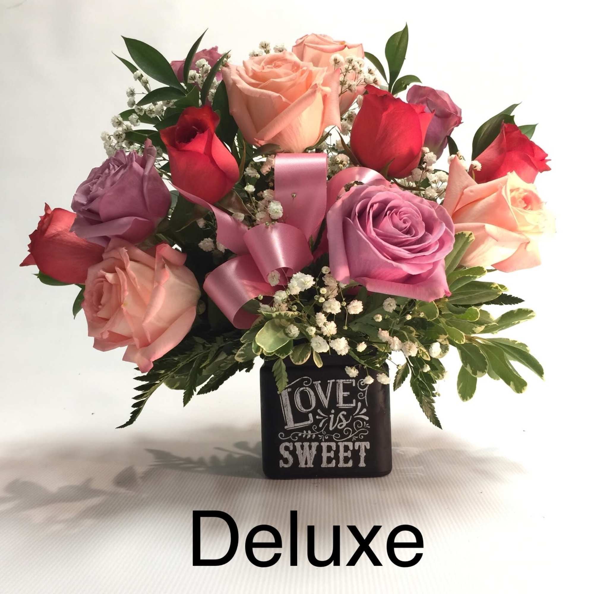 Mixed roses in a black vase with a pink ribbon and "Love is Sweet" text