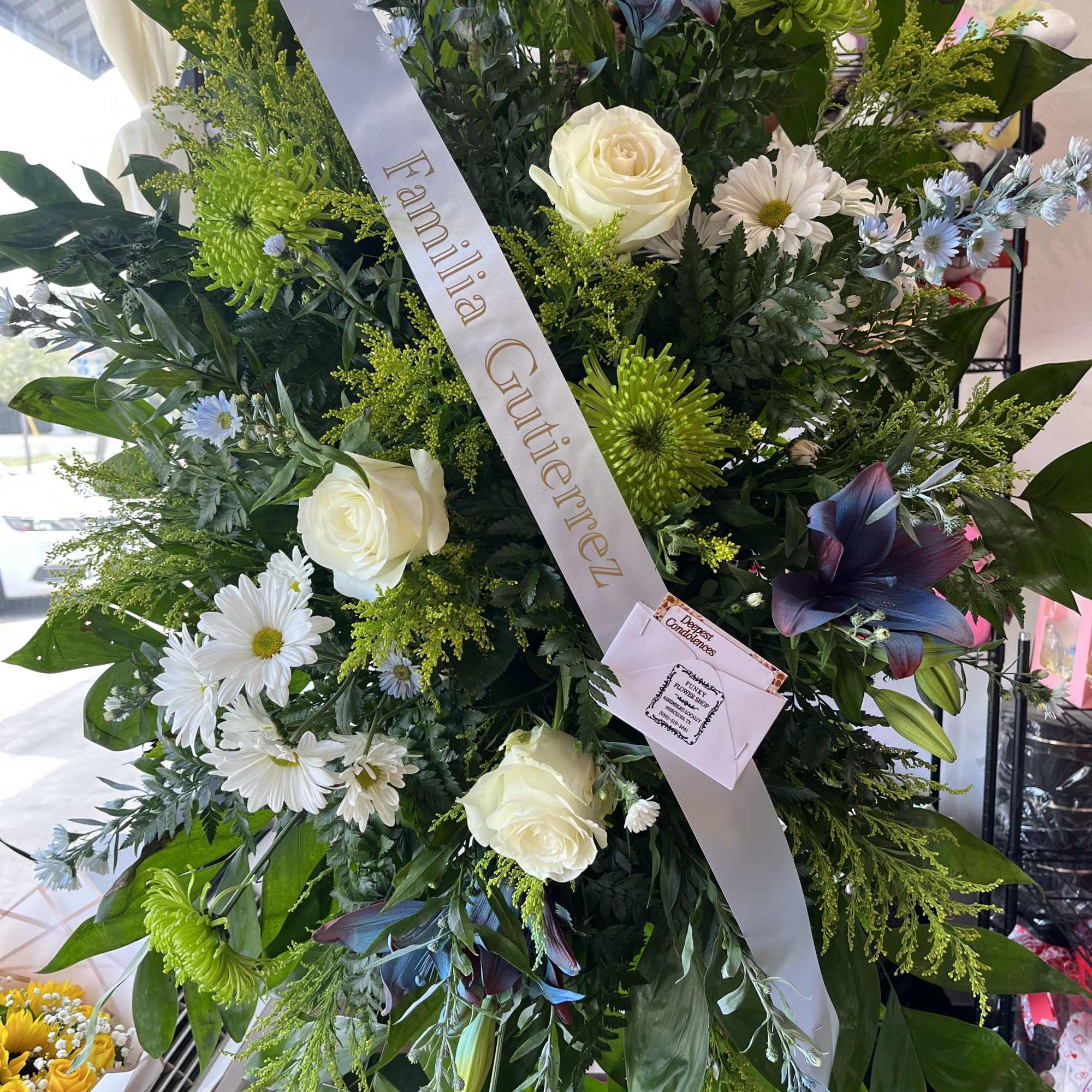 A tall, formal standing sympathy arrangement that reads as a respectful and