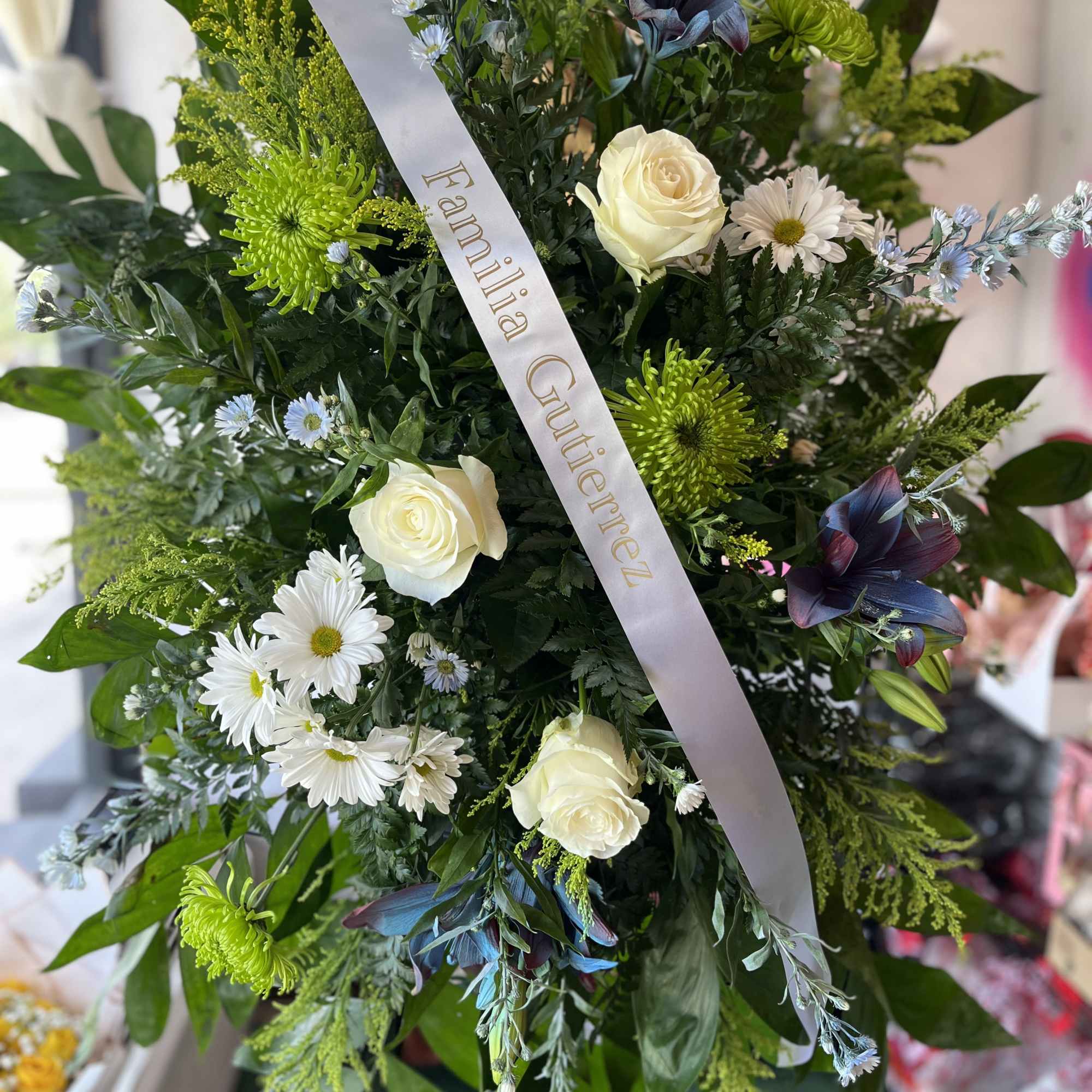 A tall, formal standing sympathy arrangement that reads as a respectful and