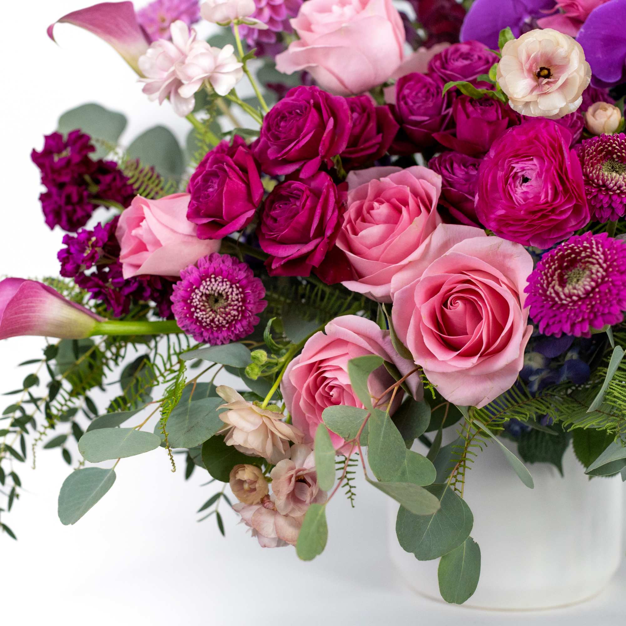 Pink and purple mixed flower arrangement in a white vase