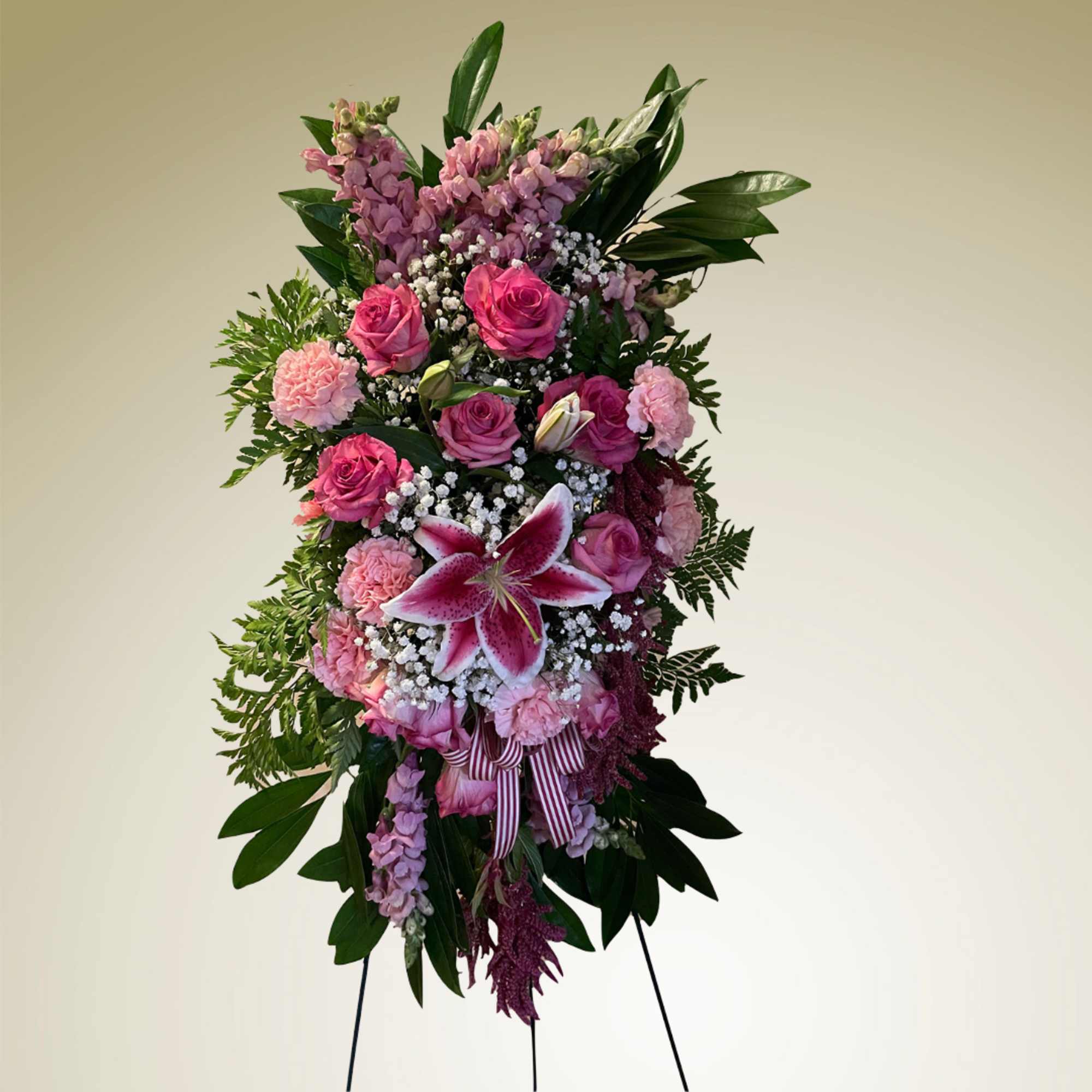Standing floral spray with pink roses and lilies on an easel