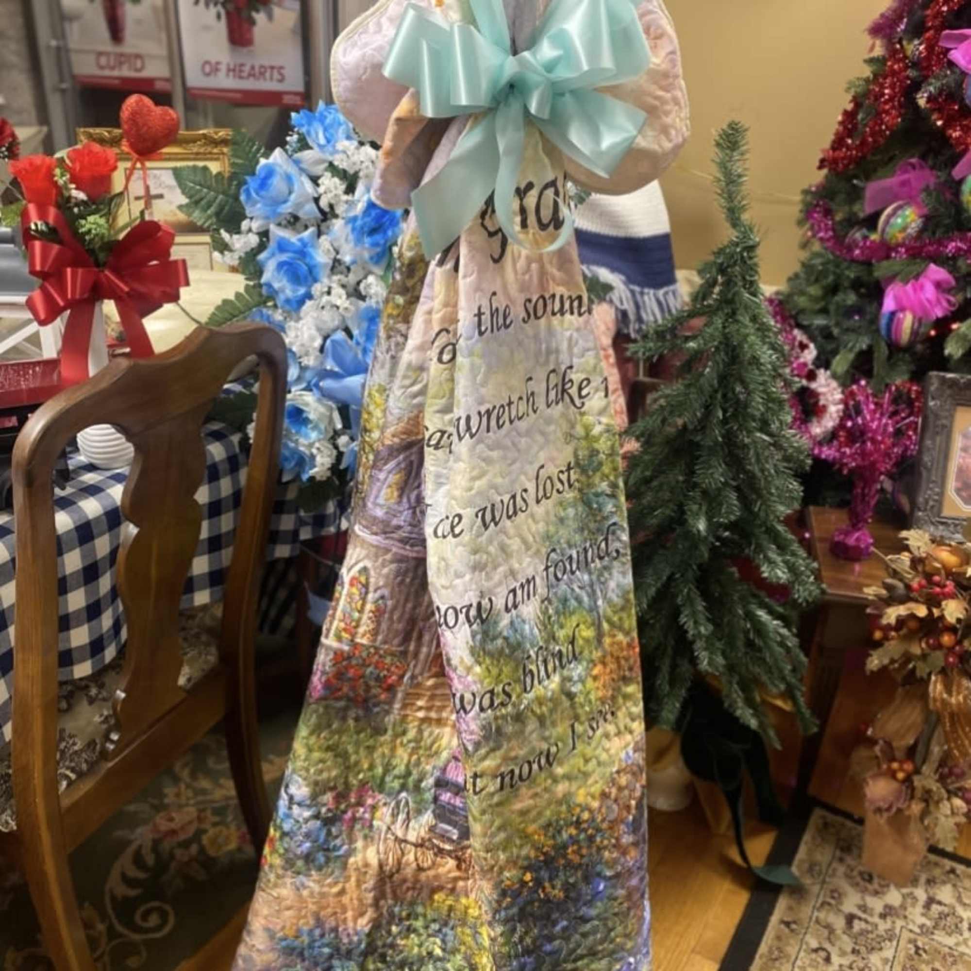 A gentle, commemorative quilt draped with a soft aqua satin bow-this memorial-style