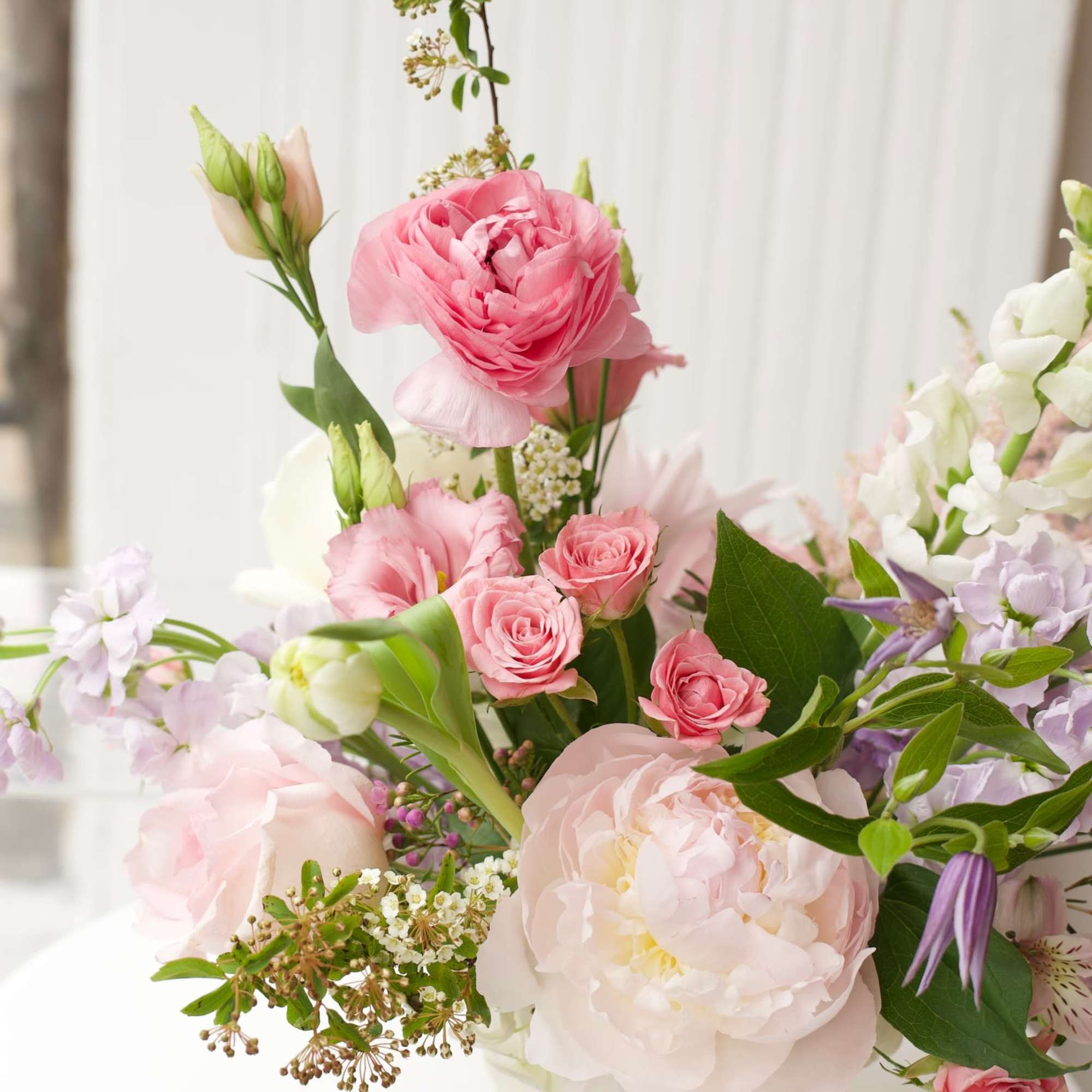 Pink and white floral arrangement in a white vase