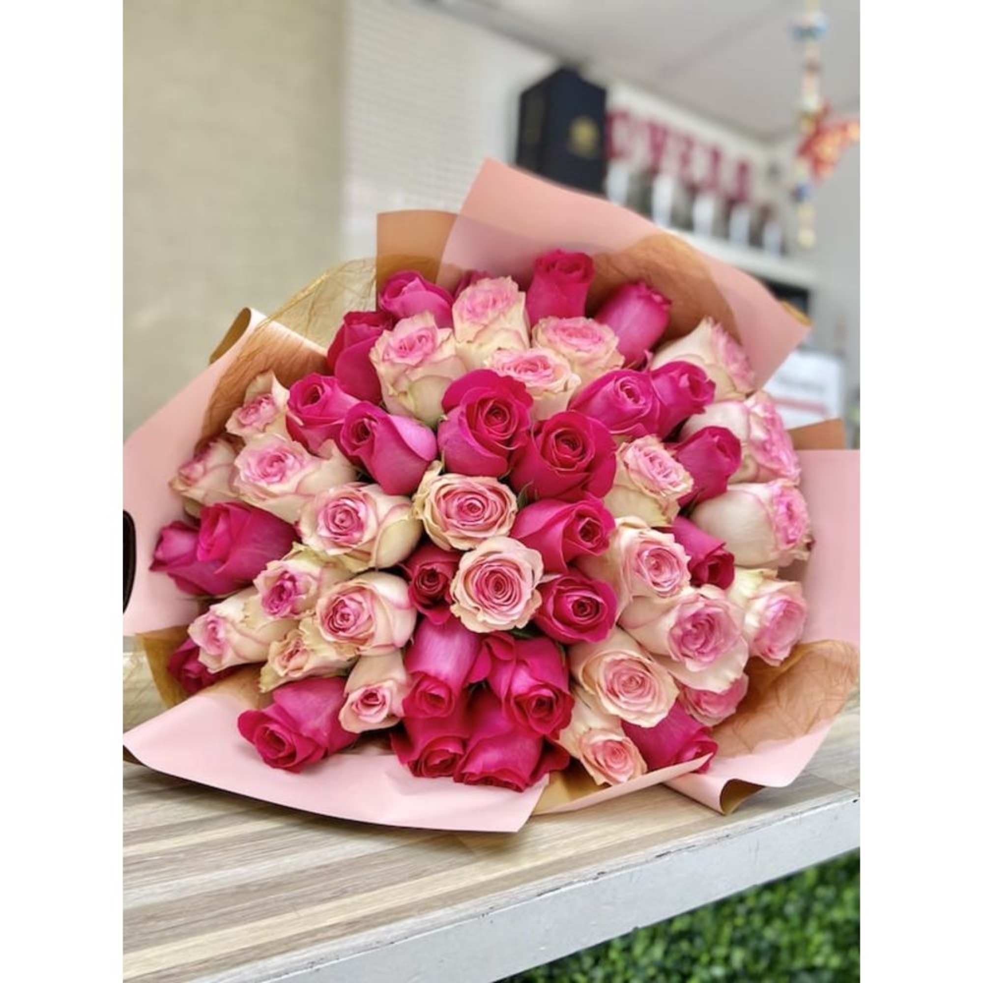 Large bouquet of hot pink and pale pink roses wrapped in pink paper