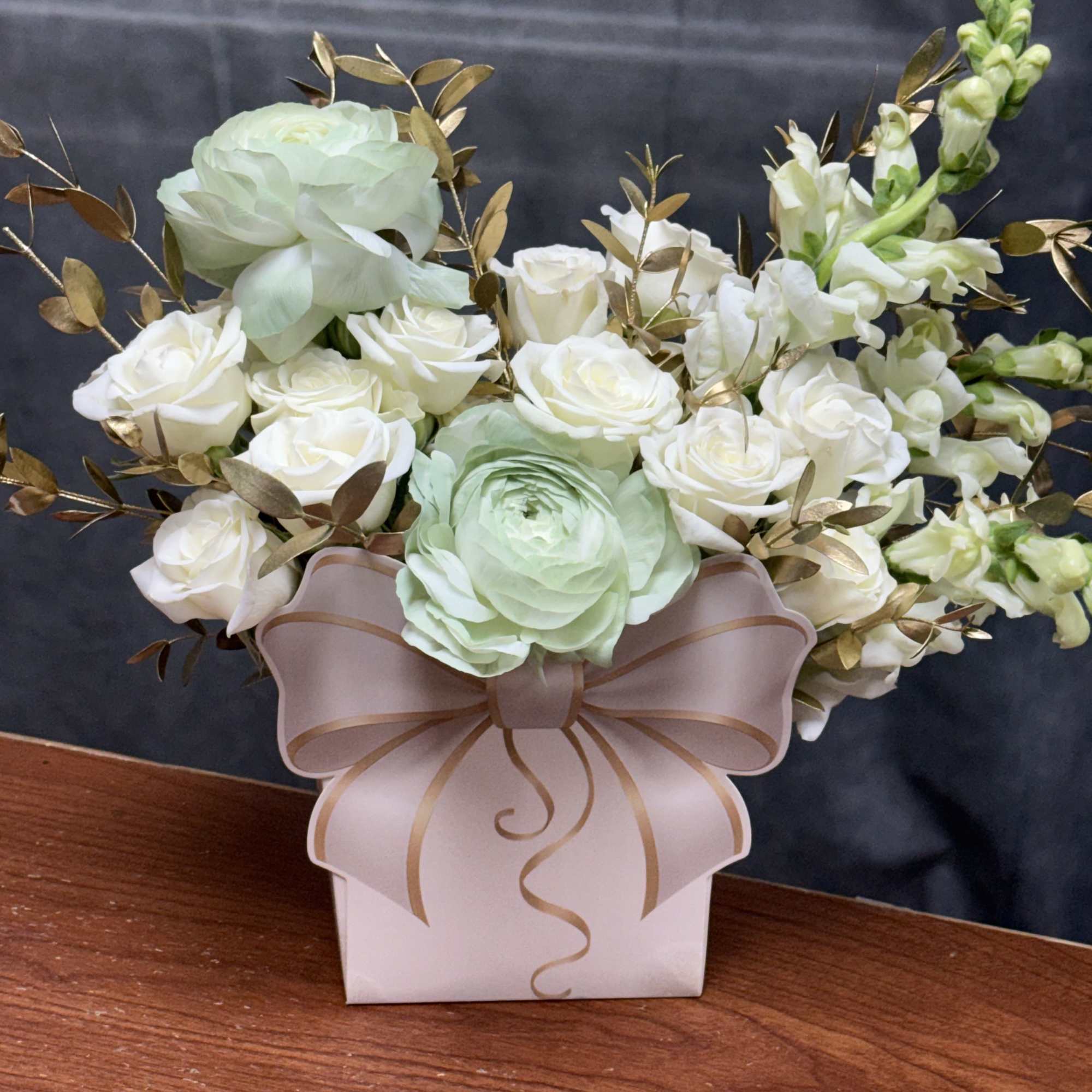 A luxurious blend of white blooms, soft green ranunculus , and gold-tinted