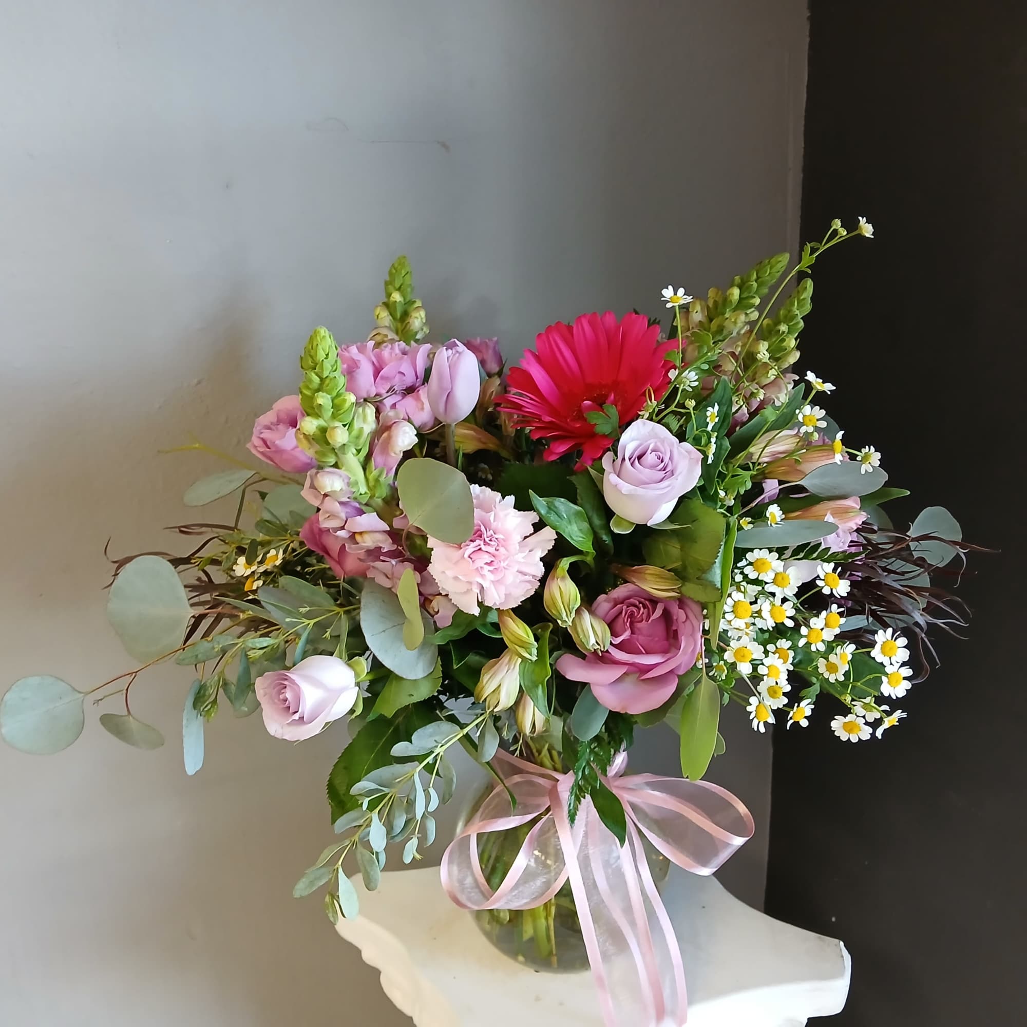 This beautiful flower arrangement of fresh mixed seasonal blooms is made by