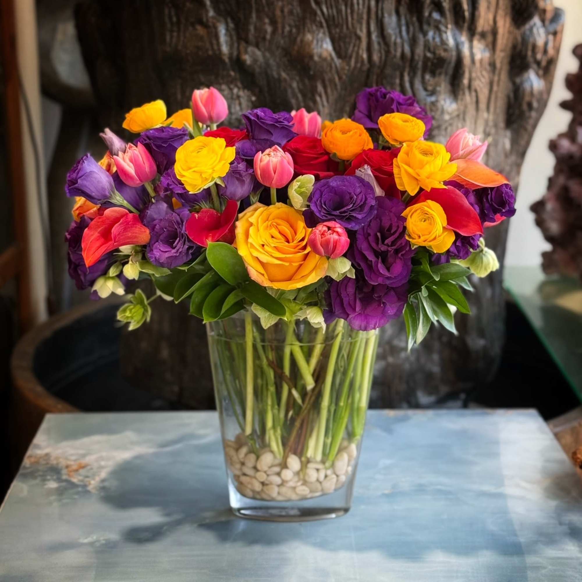 Premium Roses, Lisianthus, Tulips, Ranunculus, and more in glass vase and white