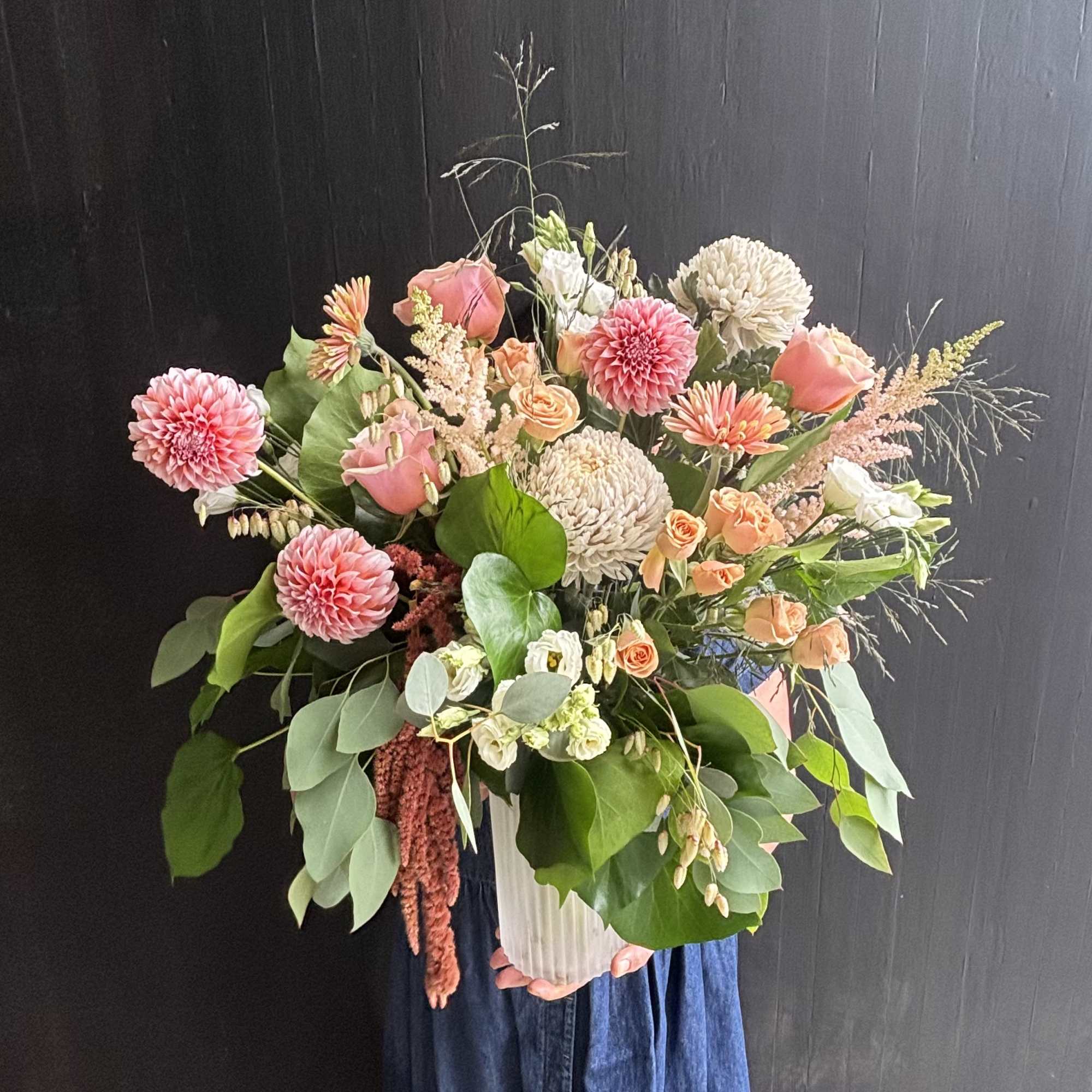 Gorgeous peach dahlias, roses, and astilbe are delicately combined to make a