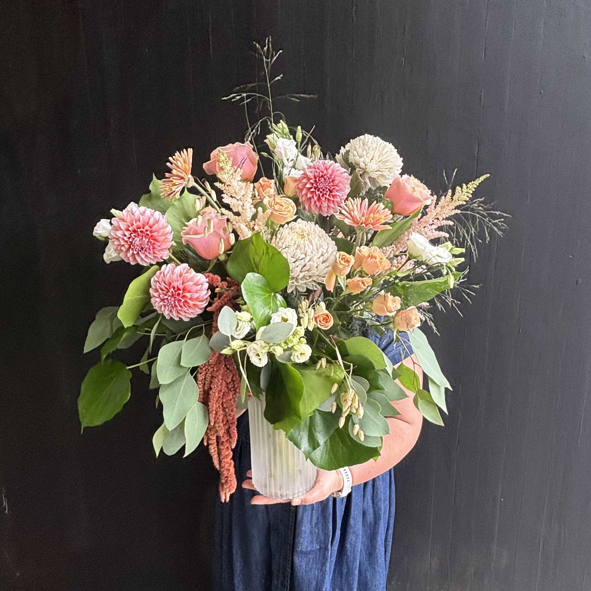 Gorgeous peach dahlias, roses, and astilbe are delicately combined to make a