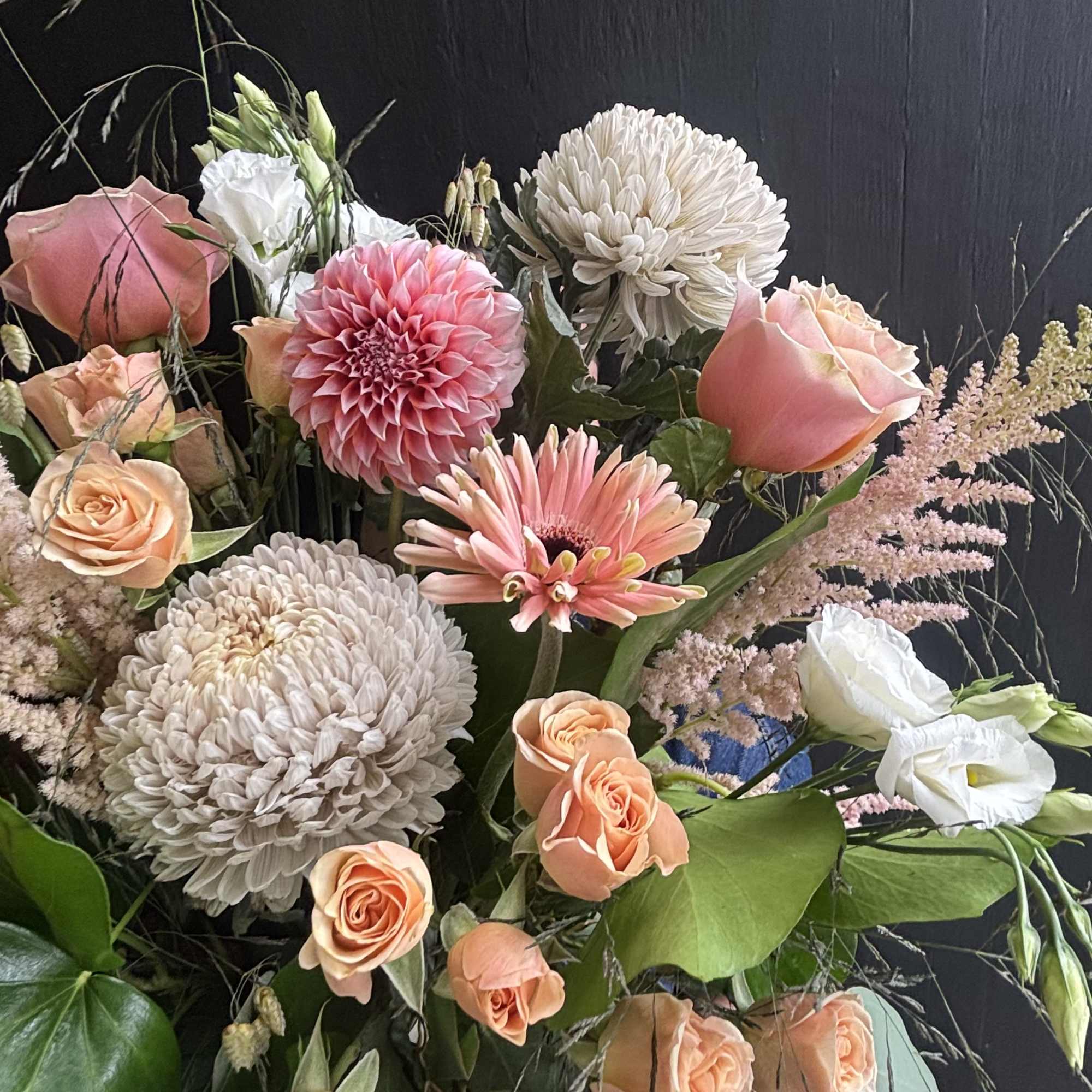 Gorgeous peach dahlias, roses, and astilbe are delicately combined to make a