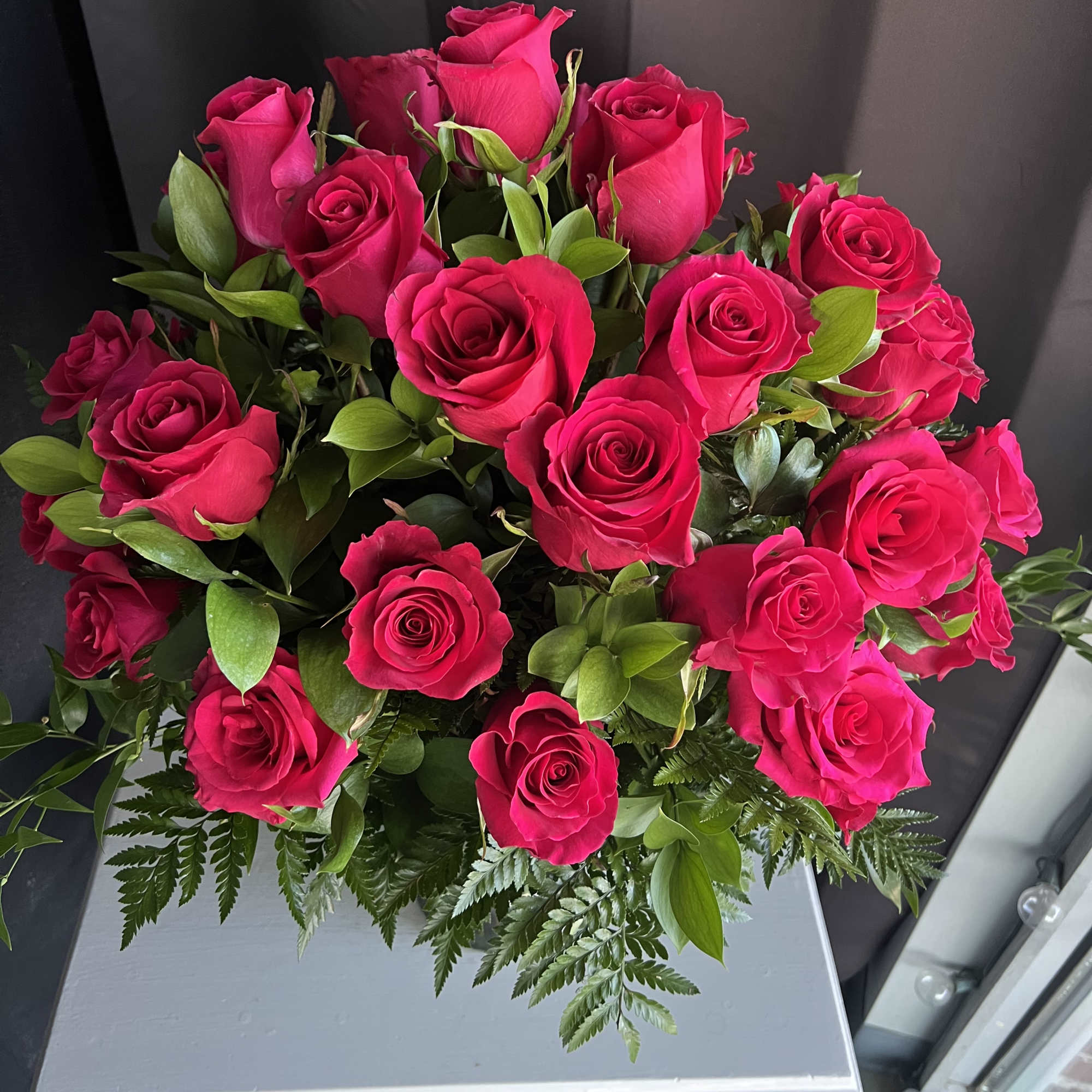 12 Hot Pink roses designed in a traditional style.
