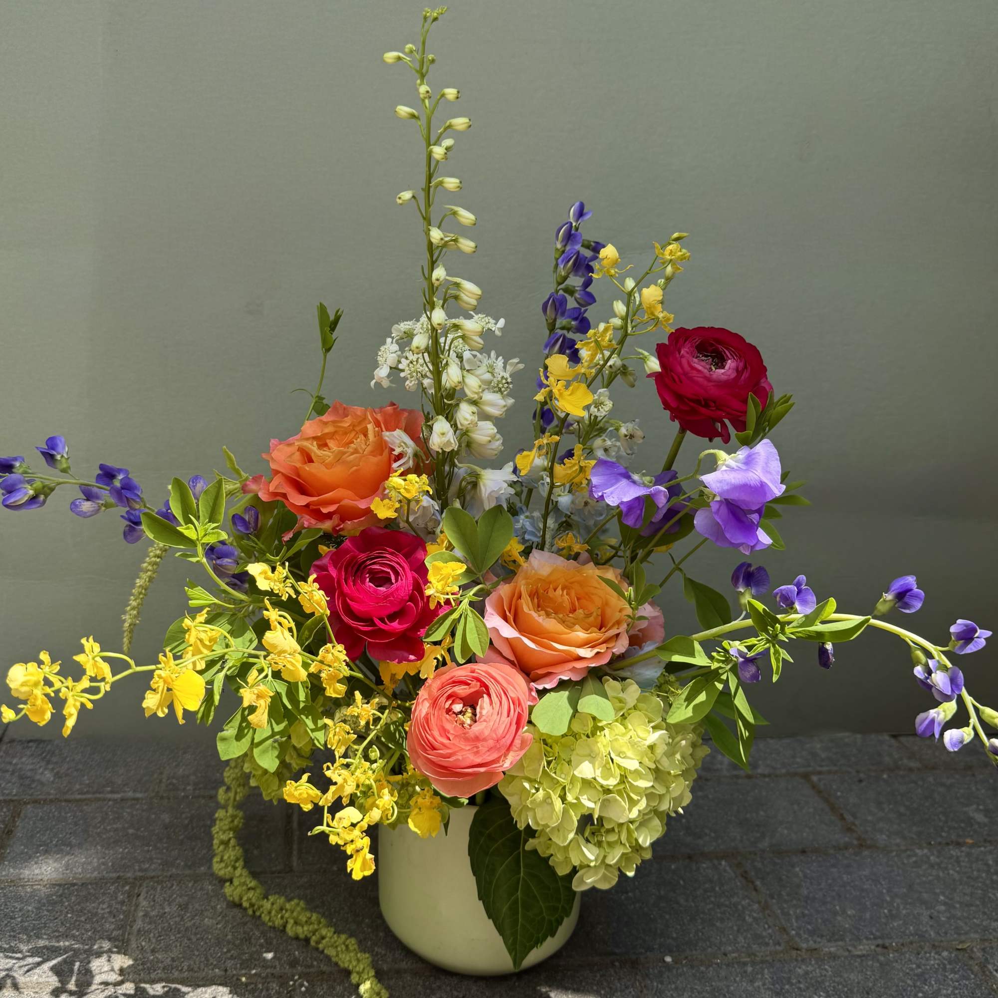 A lively garden-style mixed bouquet that bursts with warm pinks, corals and