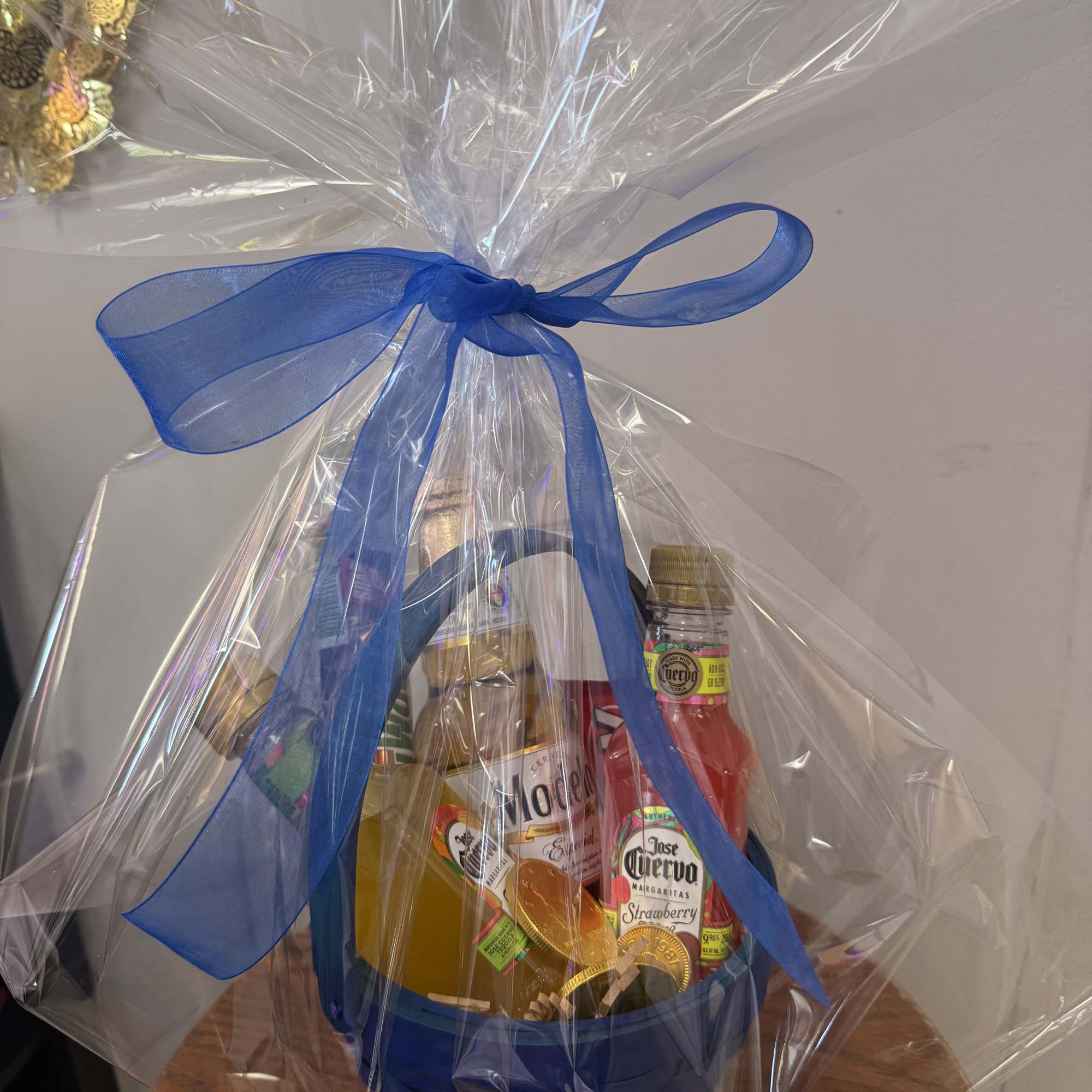 Bright blue woven basket packed with miniature liquor bottles, candy bars, and