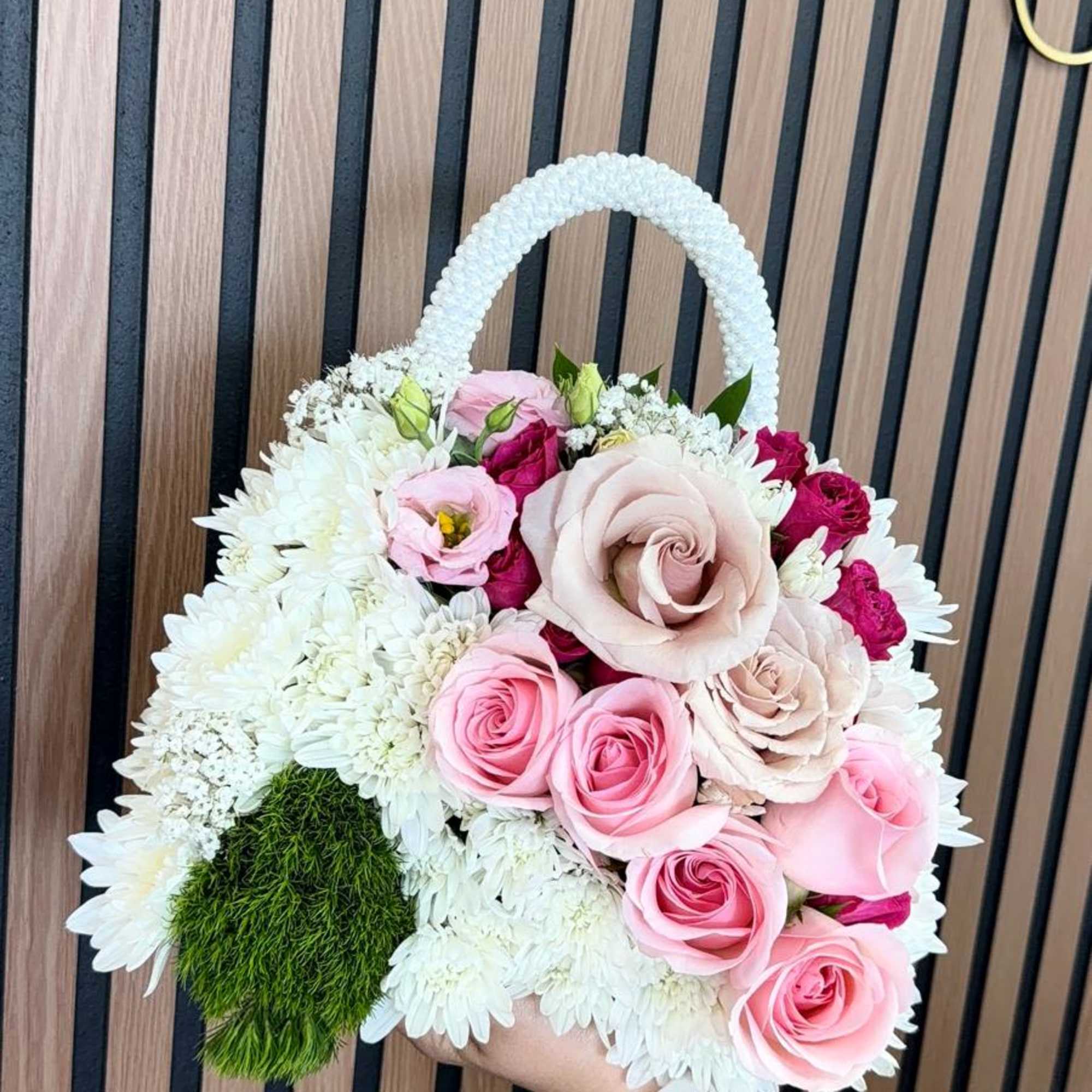 A compact, handbag-shaped floral arrangement that reads like a little luxury gift-soft