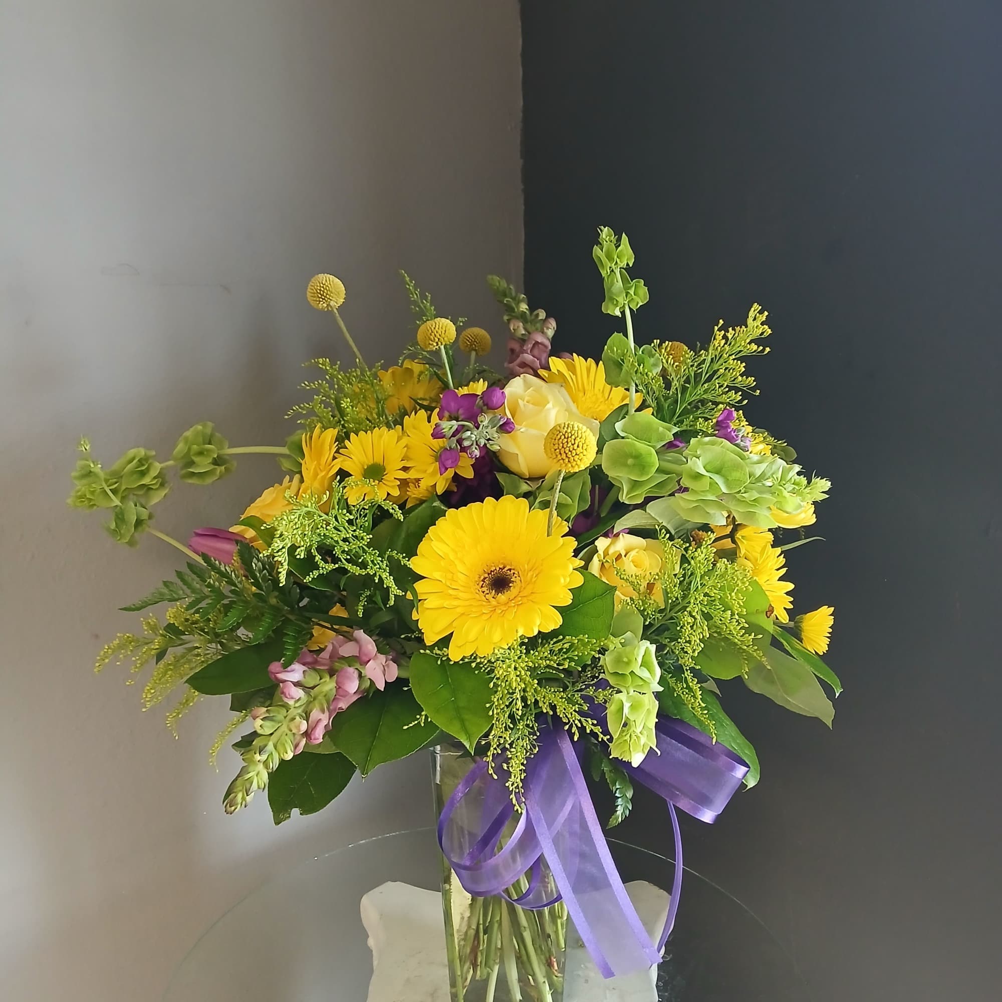 This beautiful flower arrangement of fresh mixed seasonal blooms is made by