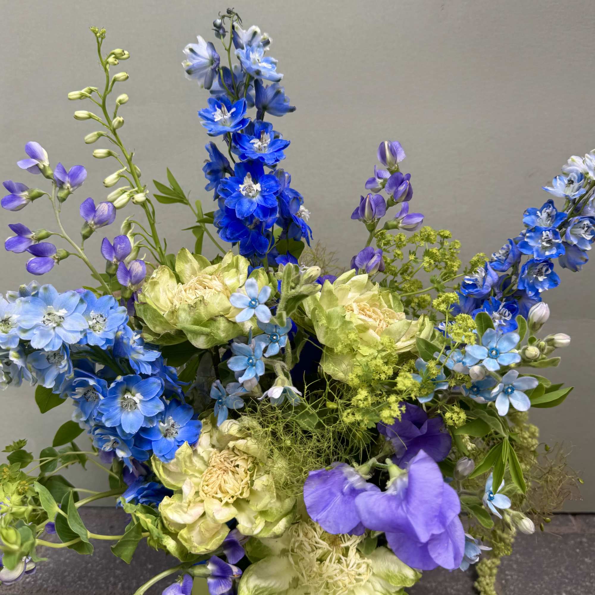 Tall spikes of blue and lavender delphinium set a dramatic, airy tone
