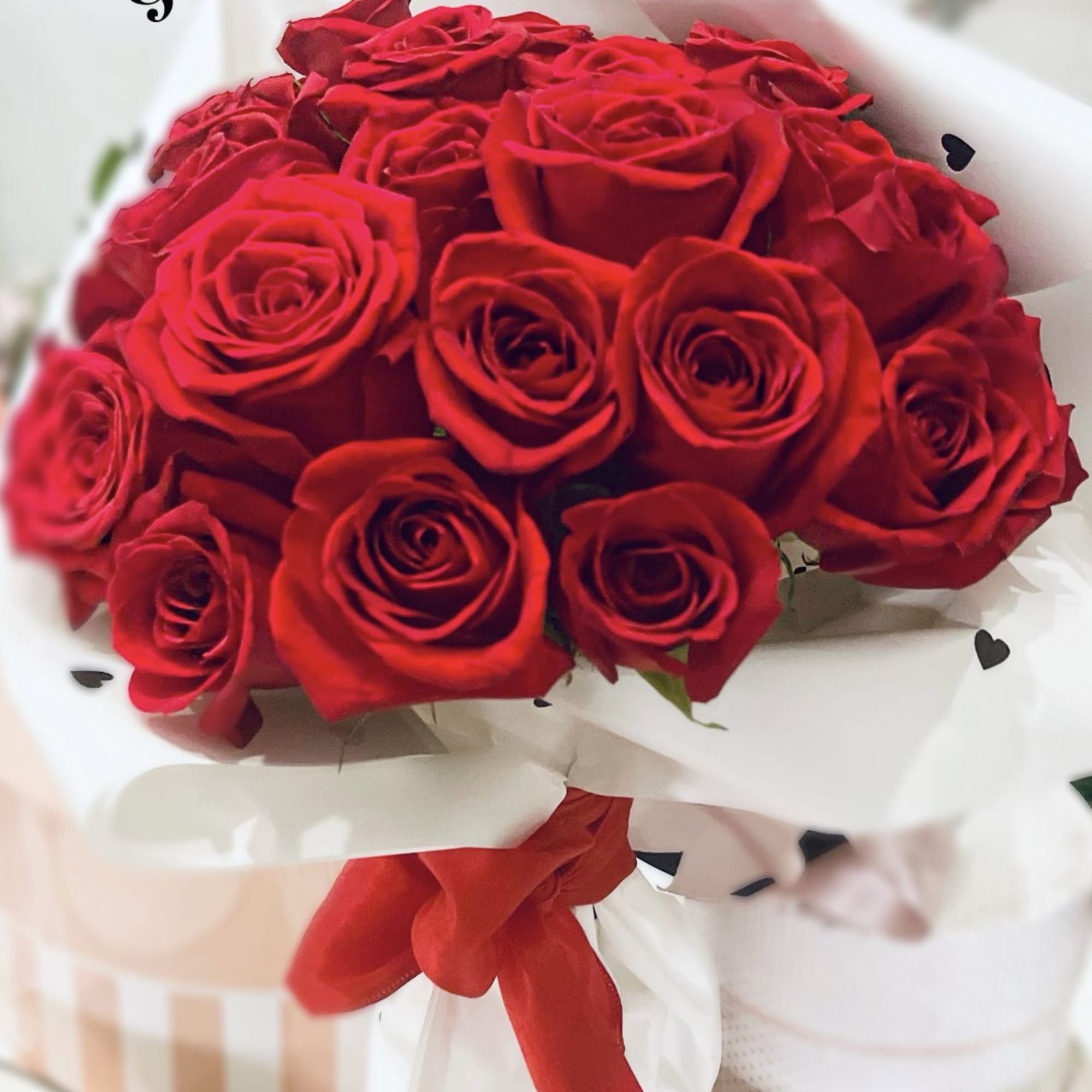 Deep, saturated red roses packed into a tight, rounded bouquet make a