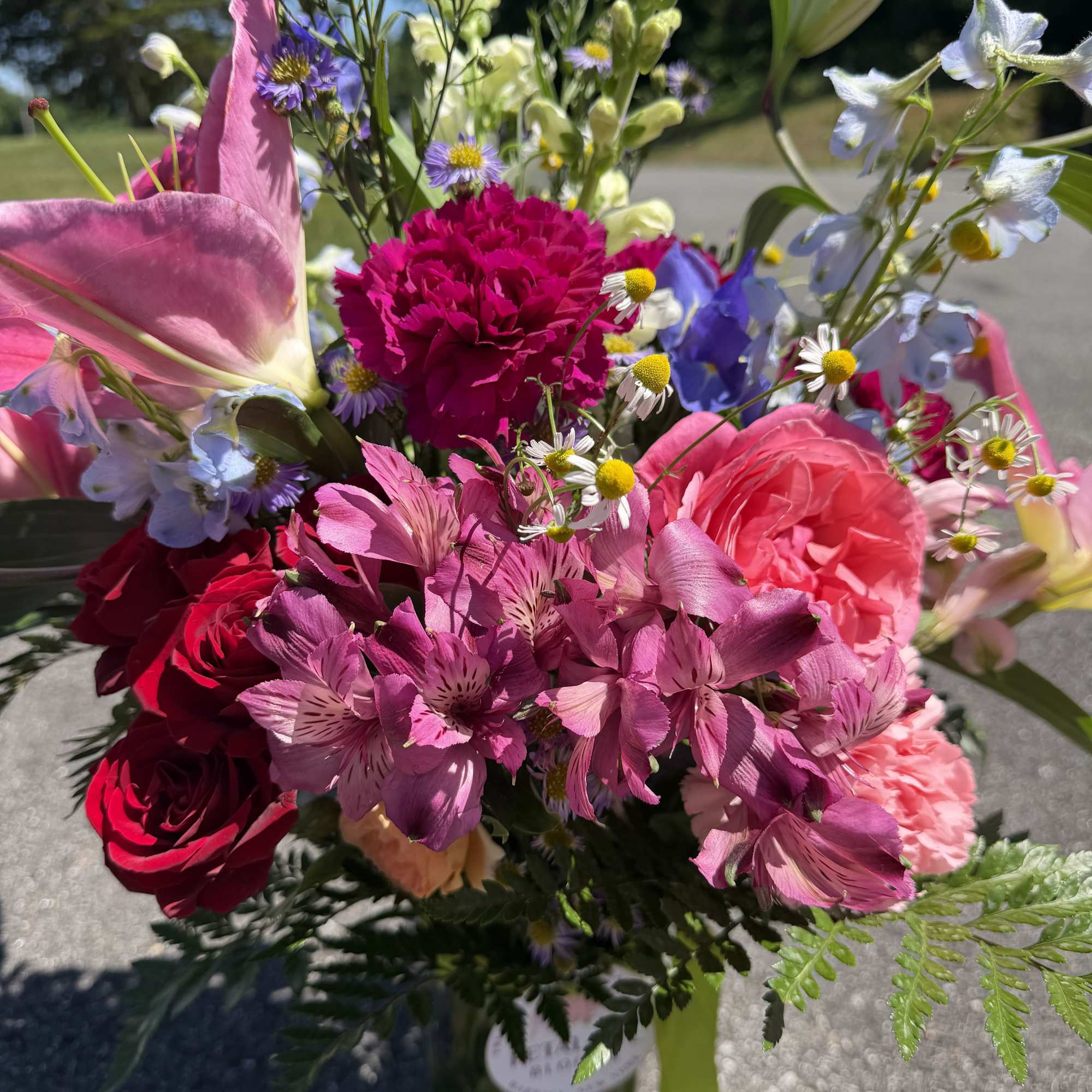 This arrangement contains stargazer lilies, bells of ireland, stock, blue iris, roses
