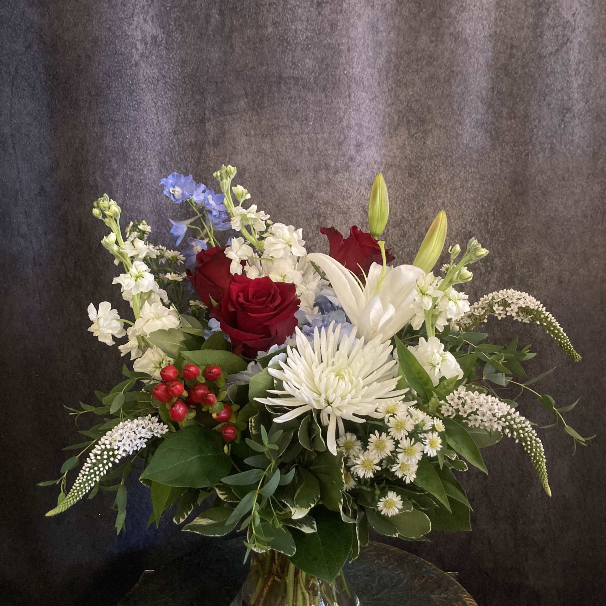 A bold, garden‑style arrangement that greets the eye with patriotic red, white