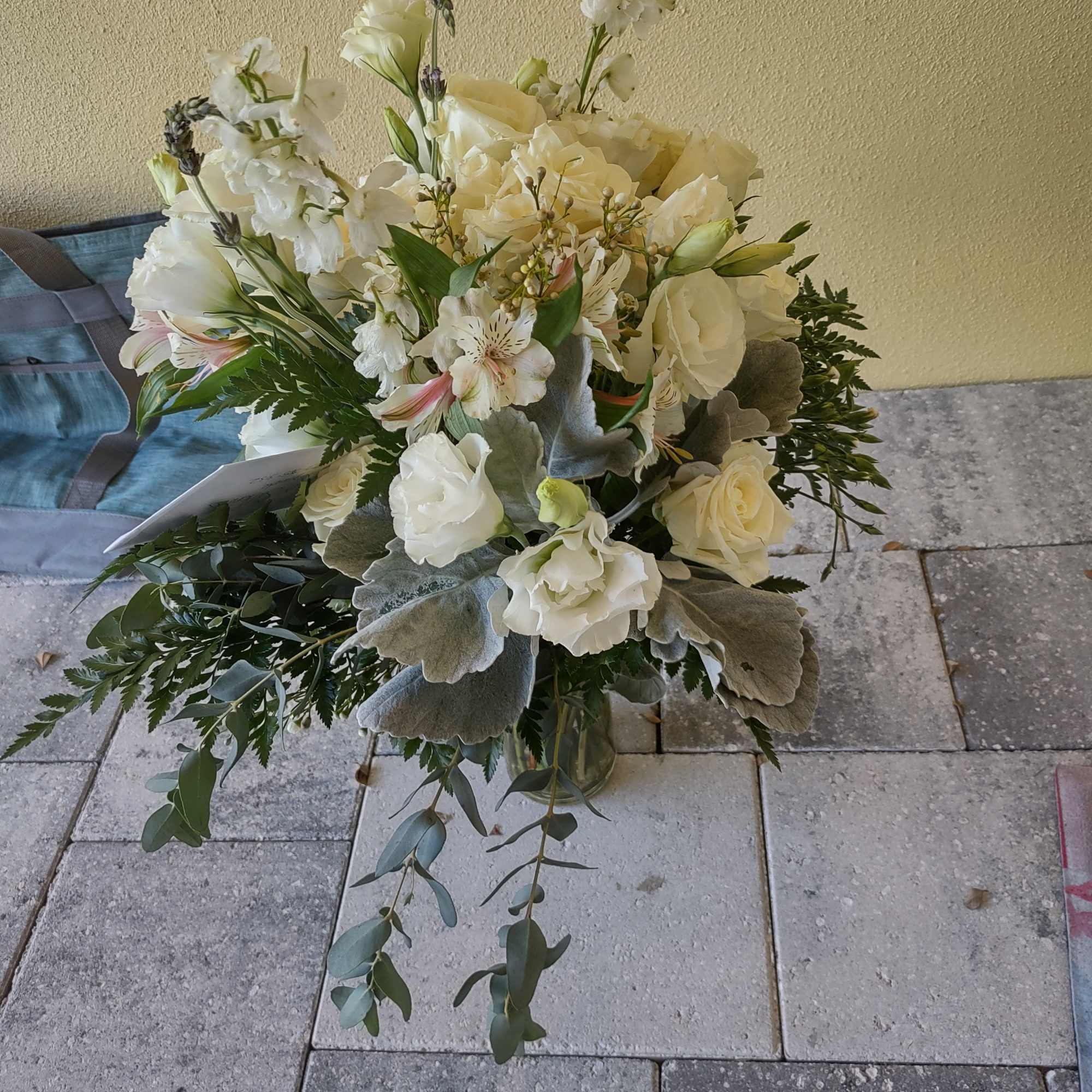 White floral bouquet with roses and orchids in a glass vase