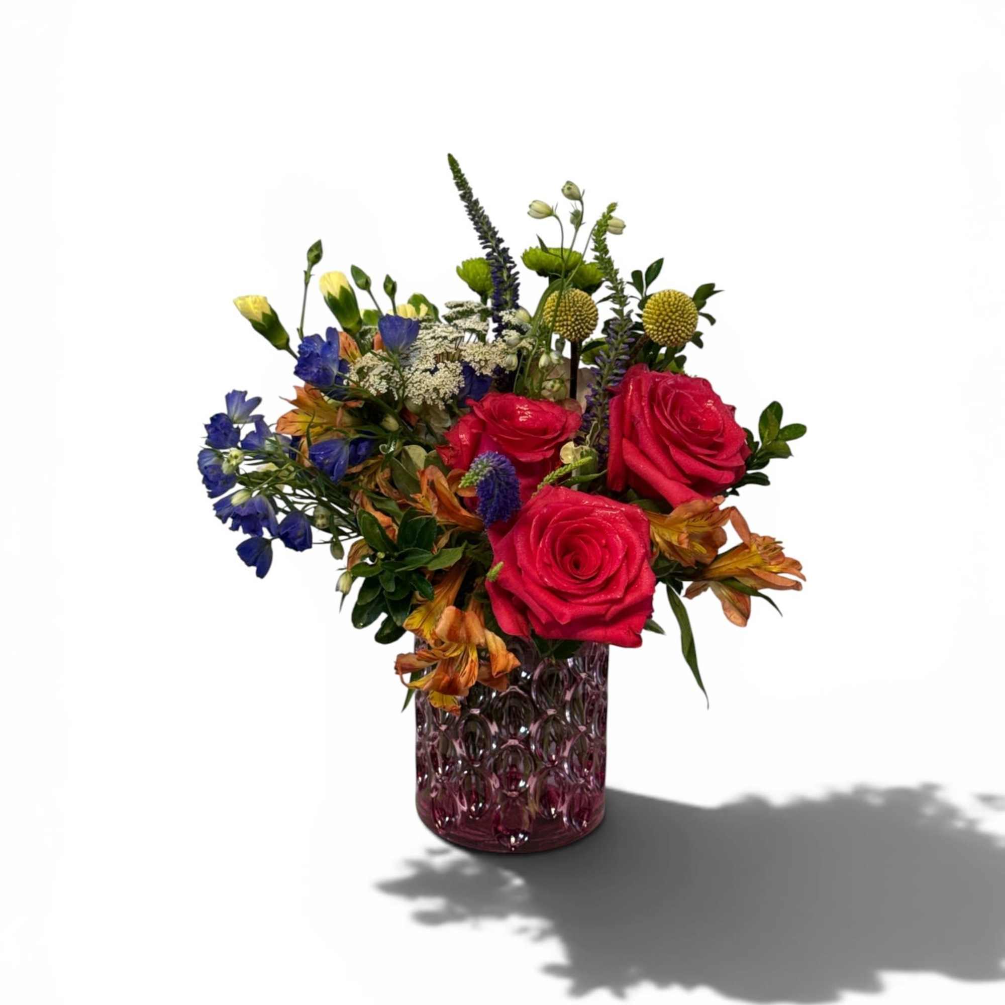Three bold Hot Pink roses take center stage in this mixed-color bouquet