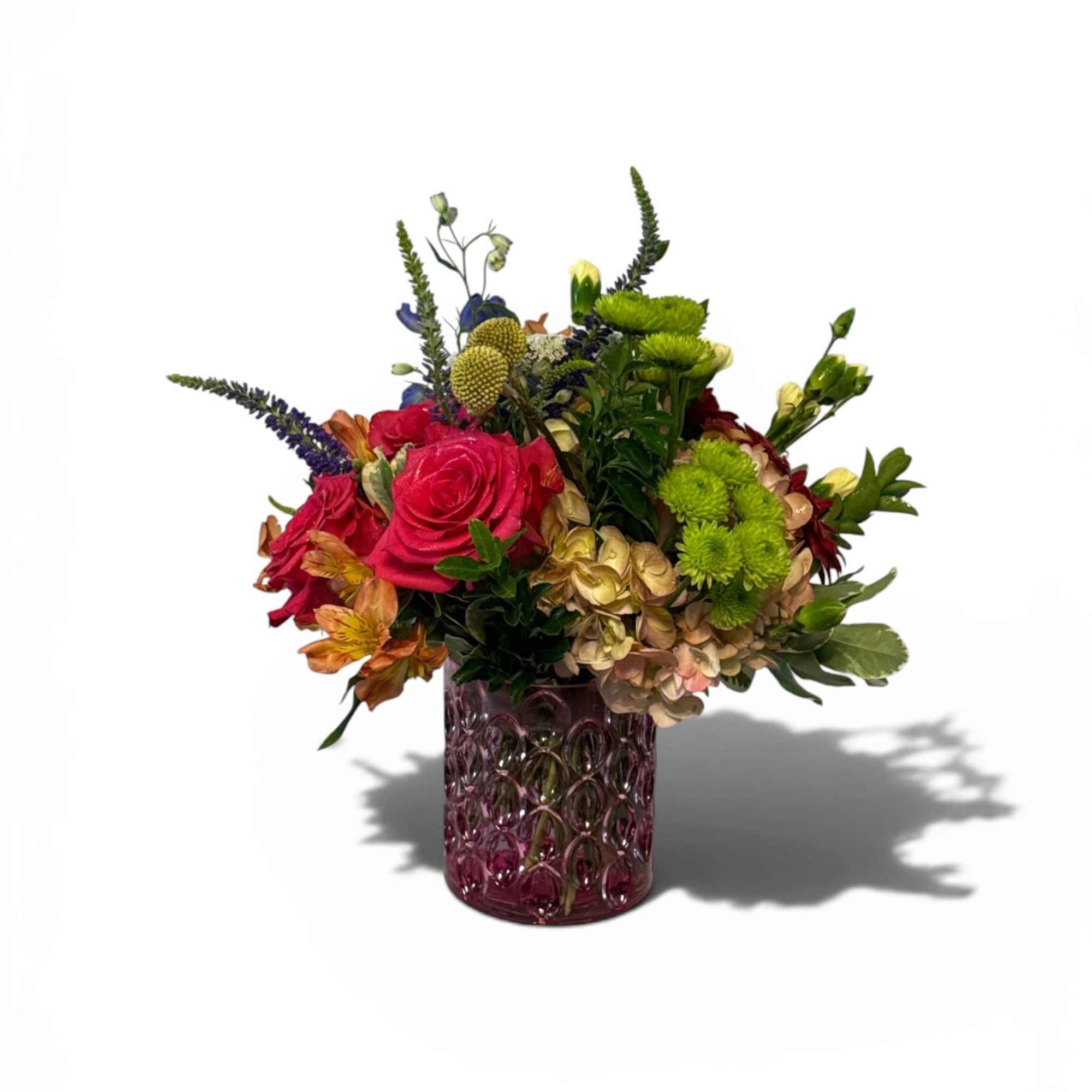 Three bold Hot Pink roses take center stage in this mixed-color bouquet