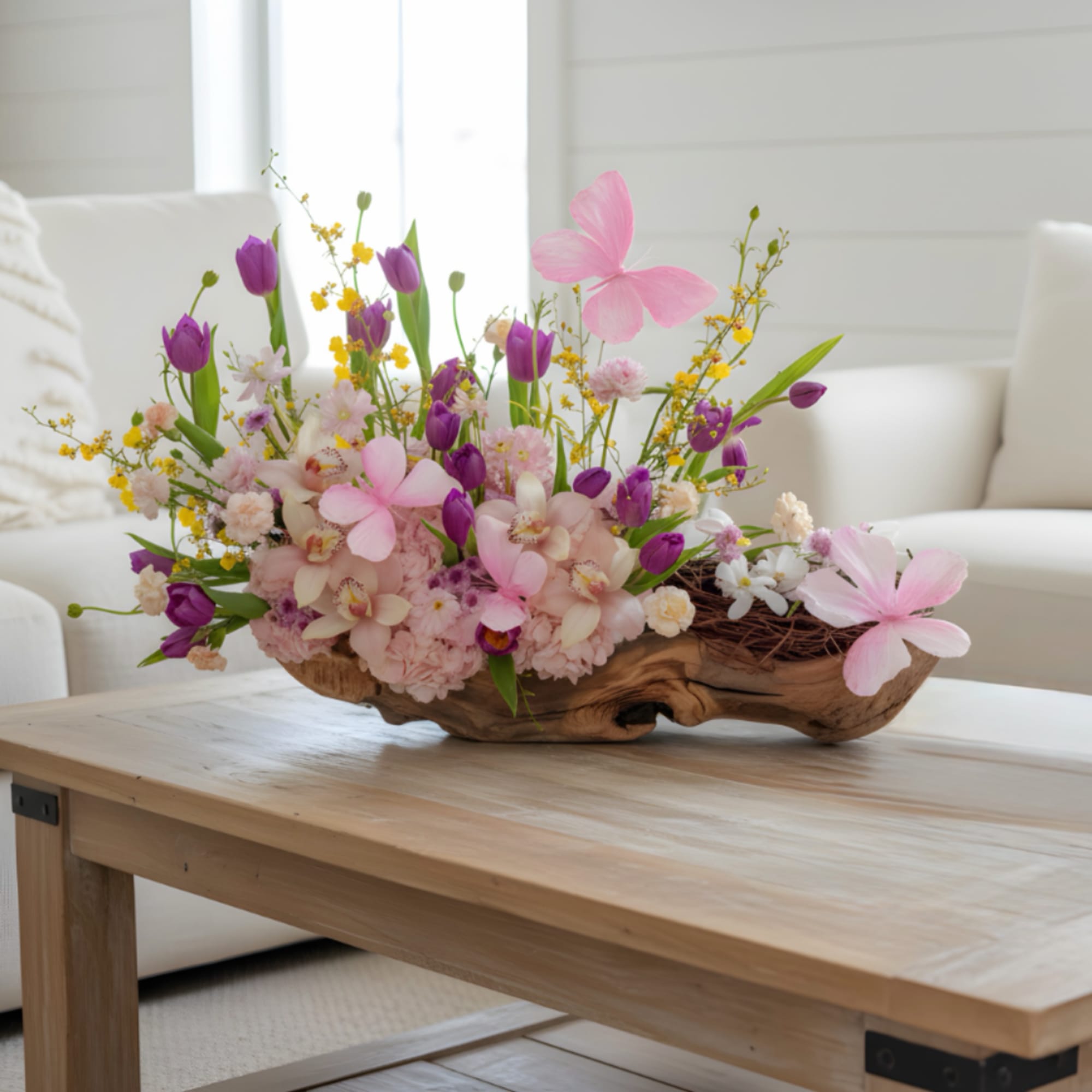 Pink hydrangeas, pink orchids and tulips with sunny yellow accents in a
