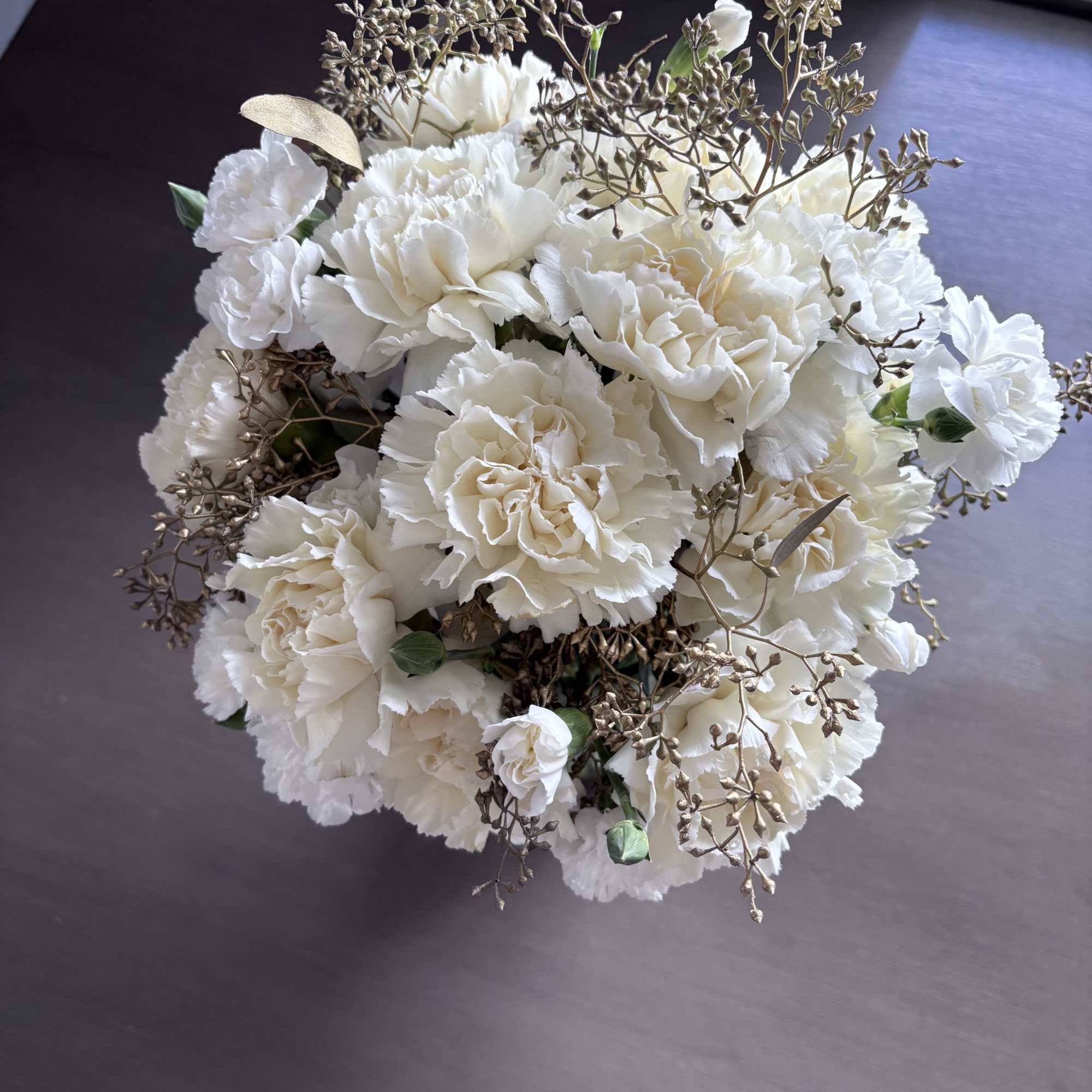 White carnation bouquet with delicate bronze filler