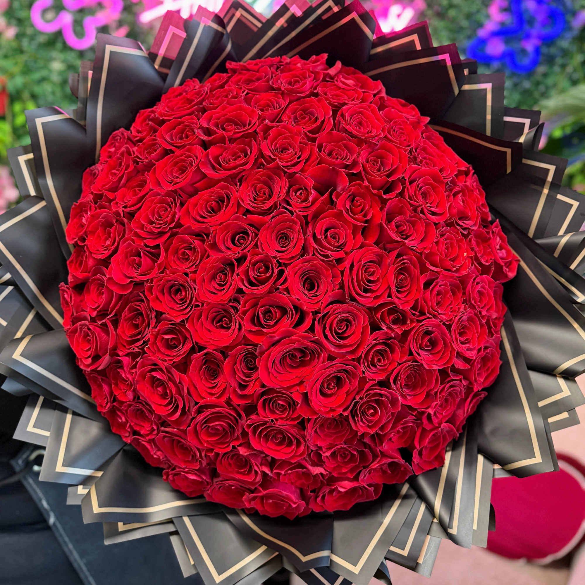 Large bouquet of red roses wrapped in black paper