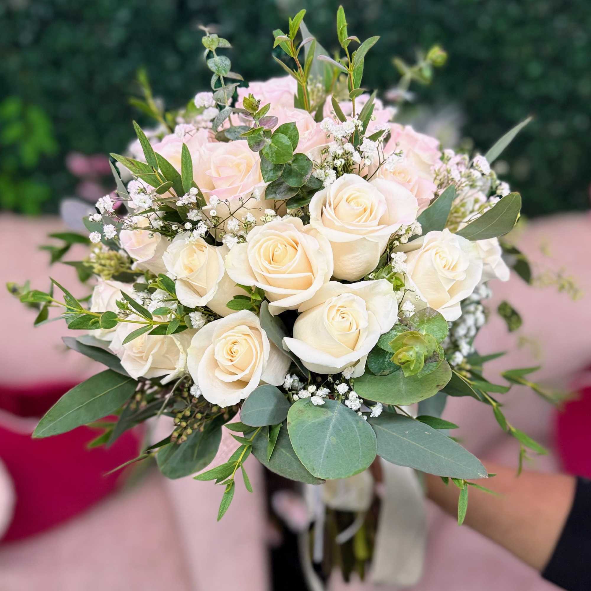 Bouquet of white roses with baby's breath and greenery