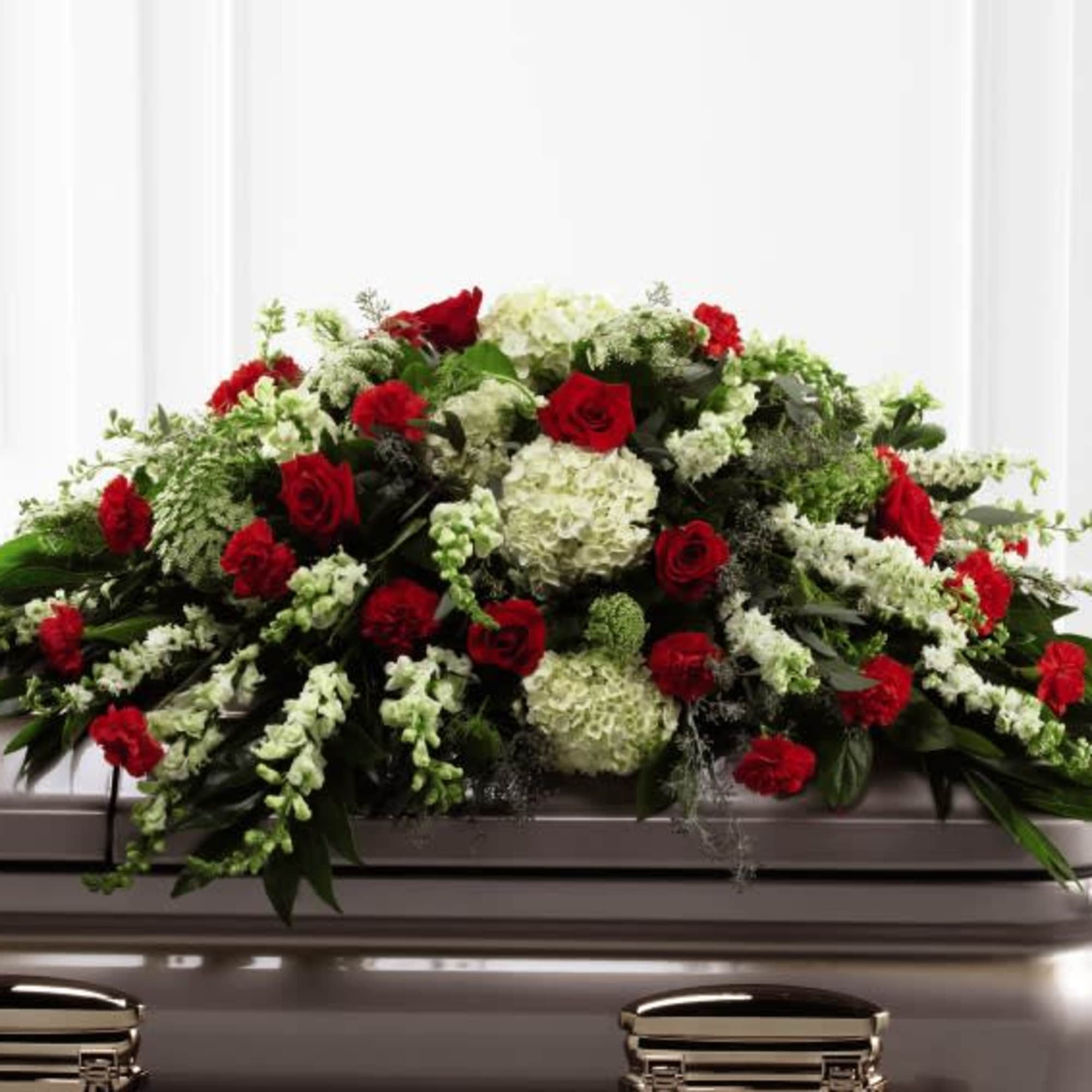 Red and white floral spray on a casket