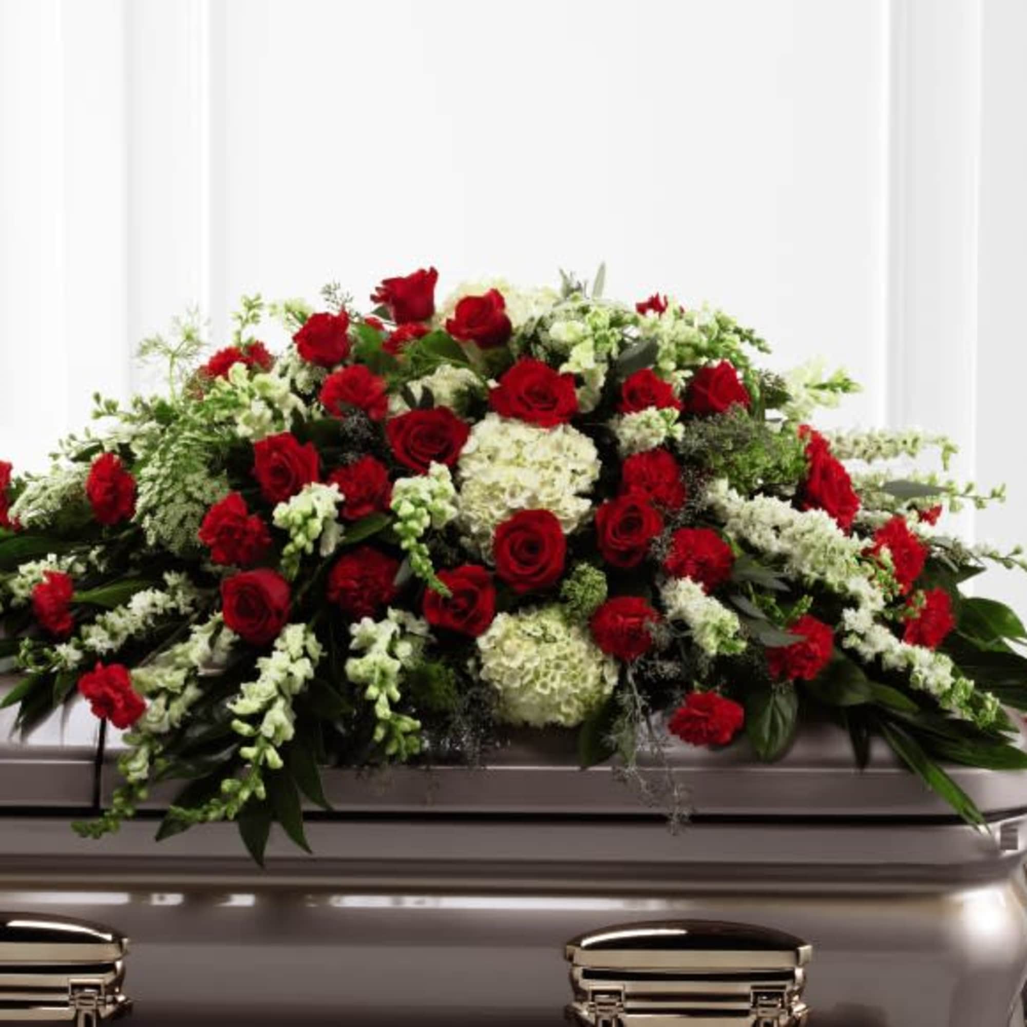 Red roses and white flowers arranged on a casket