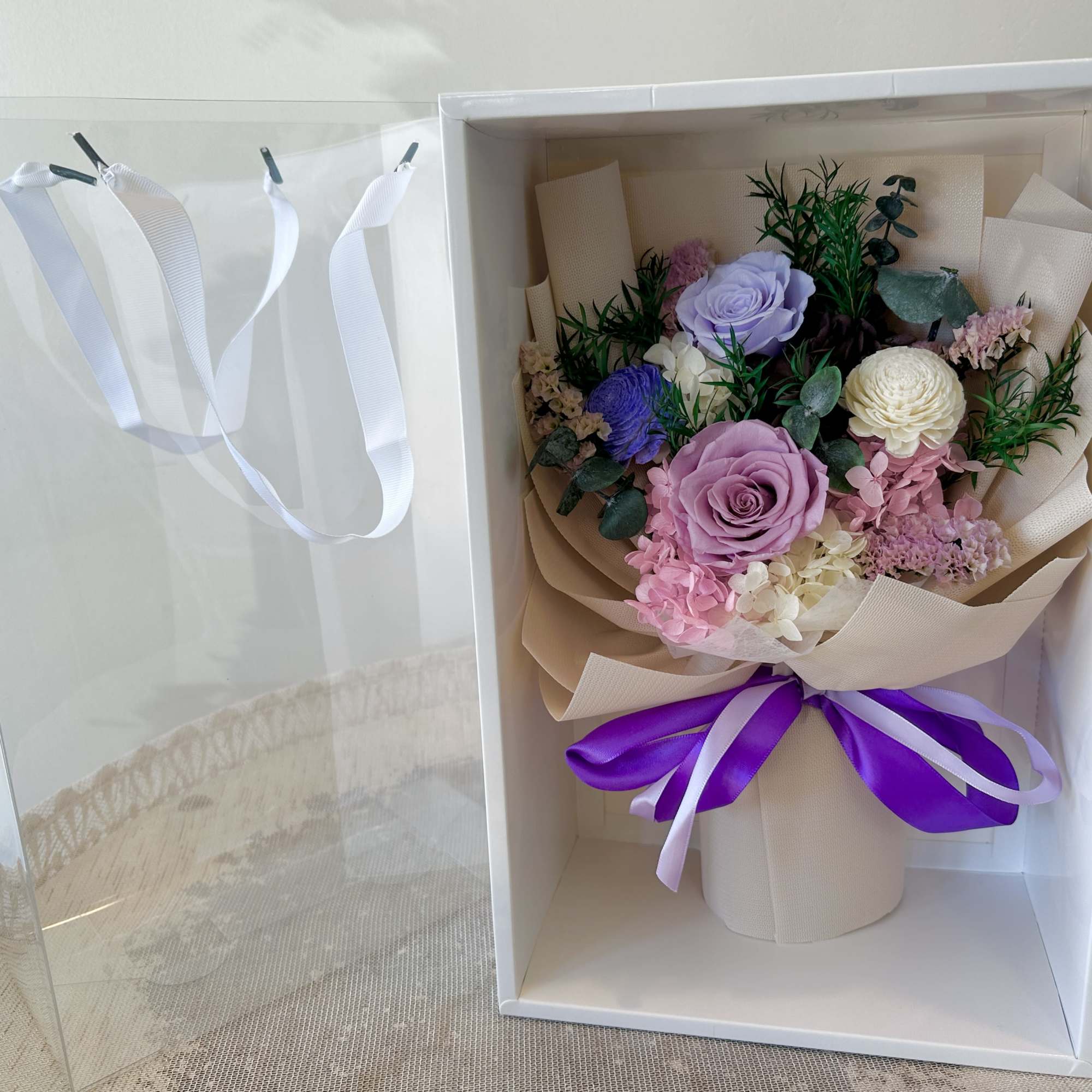 Lavender and blush roses take center stage in this preserved flower arrangement