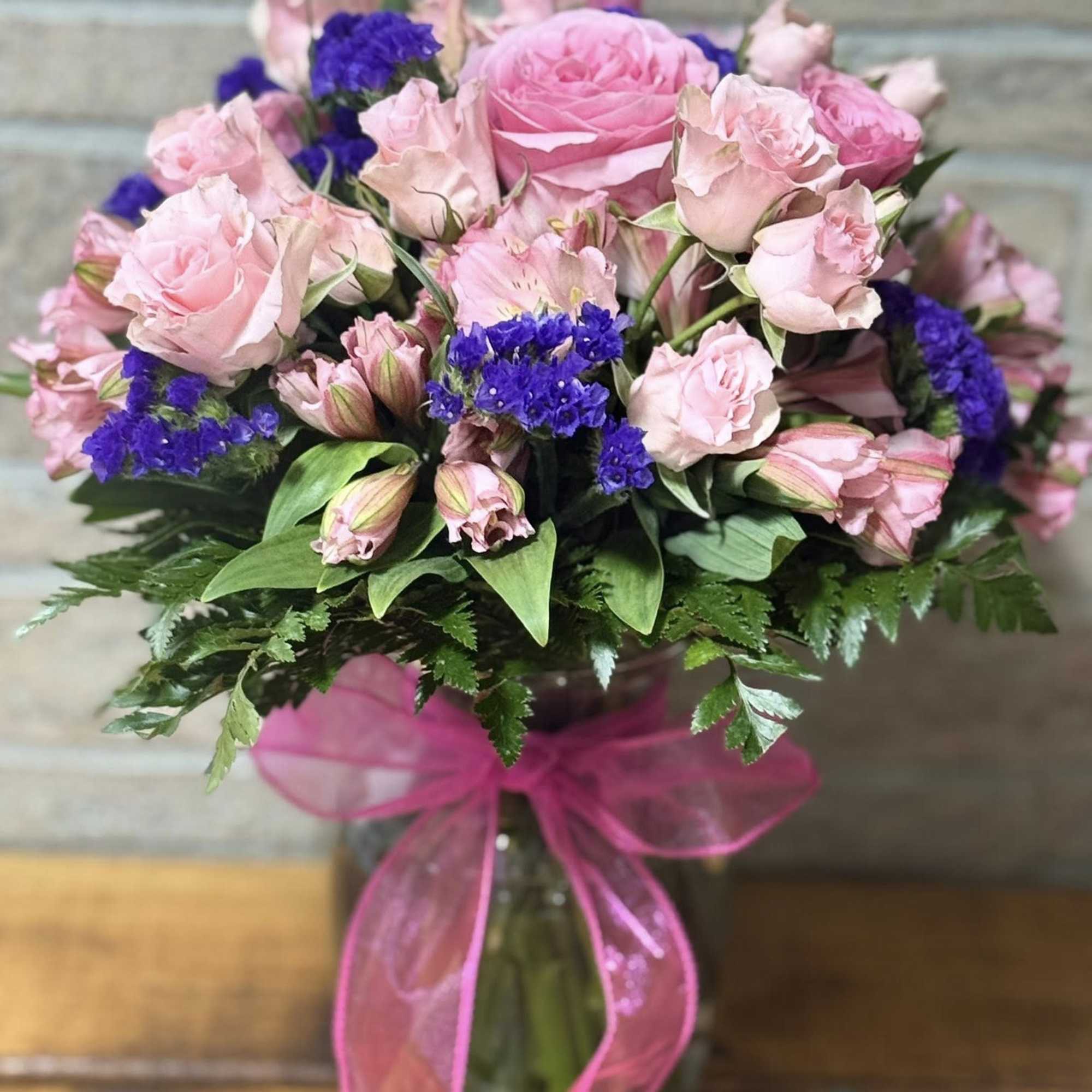 The Blushing Amethyst Garden is a lush floral arrangement featuring a romantic