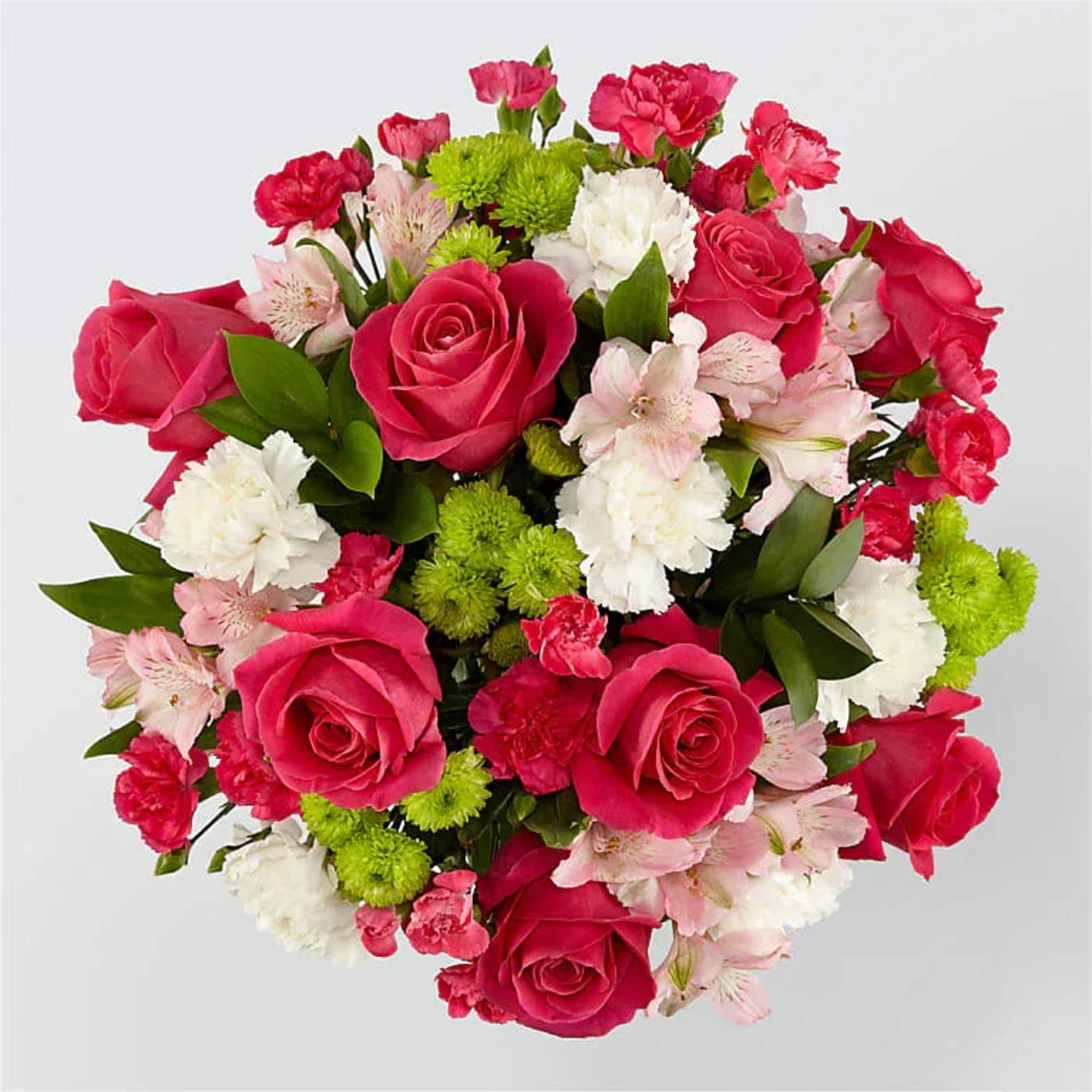 Round arrangement of hot pink roses, white carnations, pink alstroemeria, and green button mums.