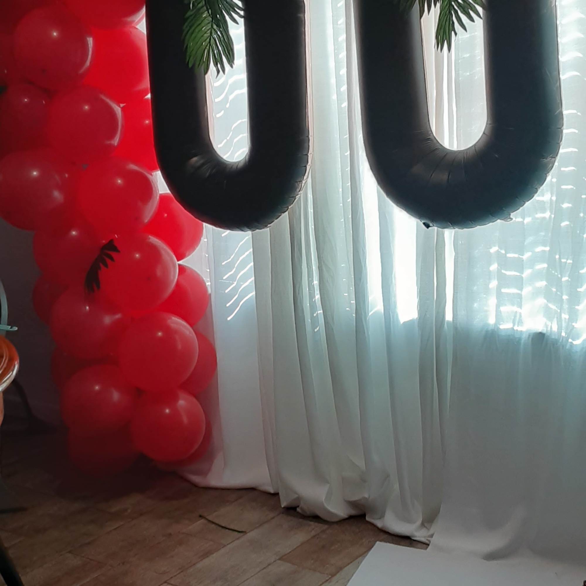 Black and red balloon arch with large black number balloons