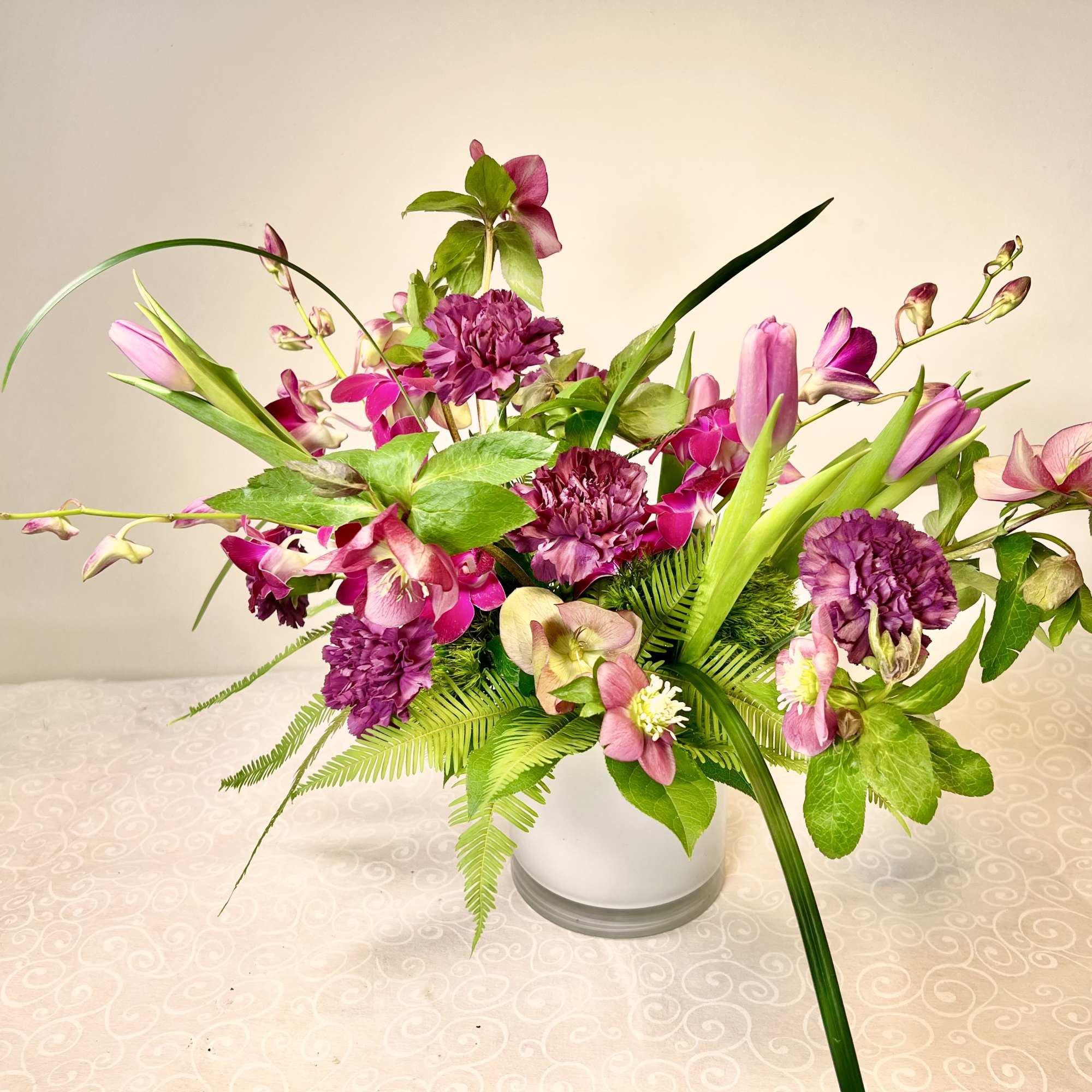 Pink and purple floral arrangement in a white vase