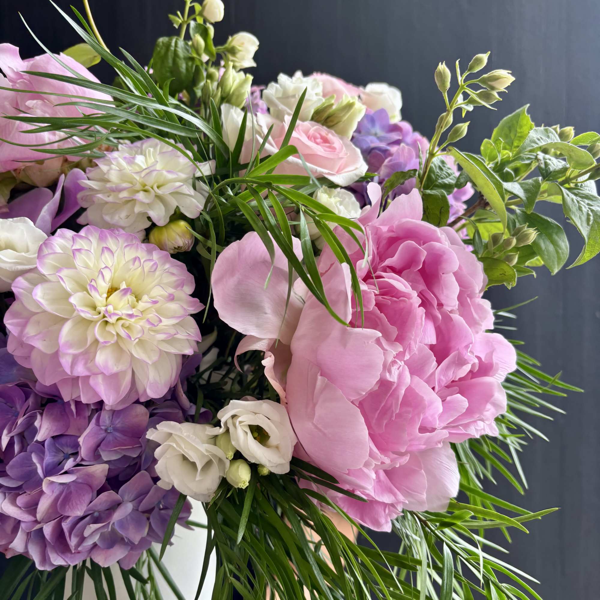 A bouquet of silky white roses, vibrant dahlias, peonies, and hydrangeas. 

Our