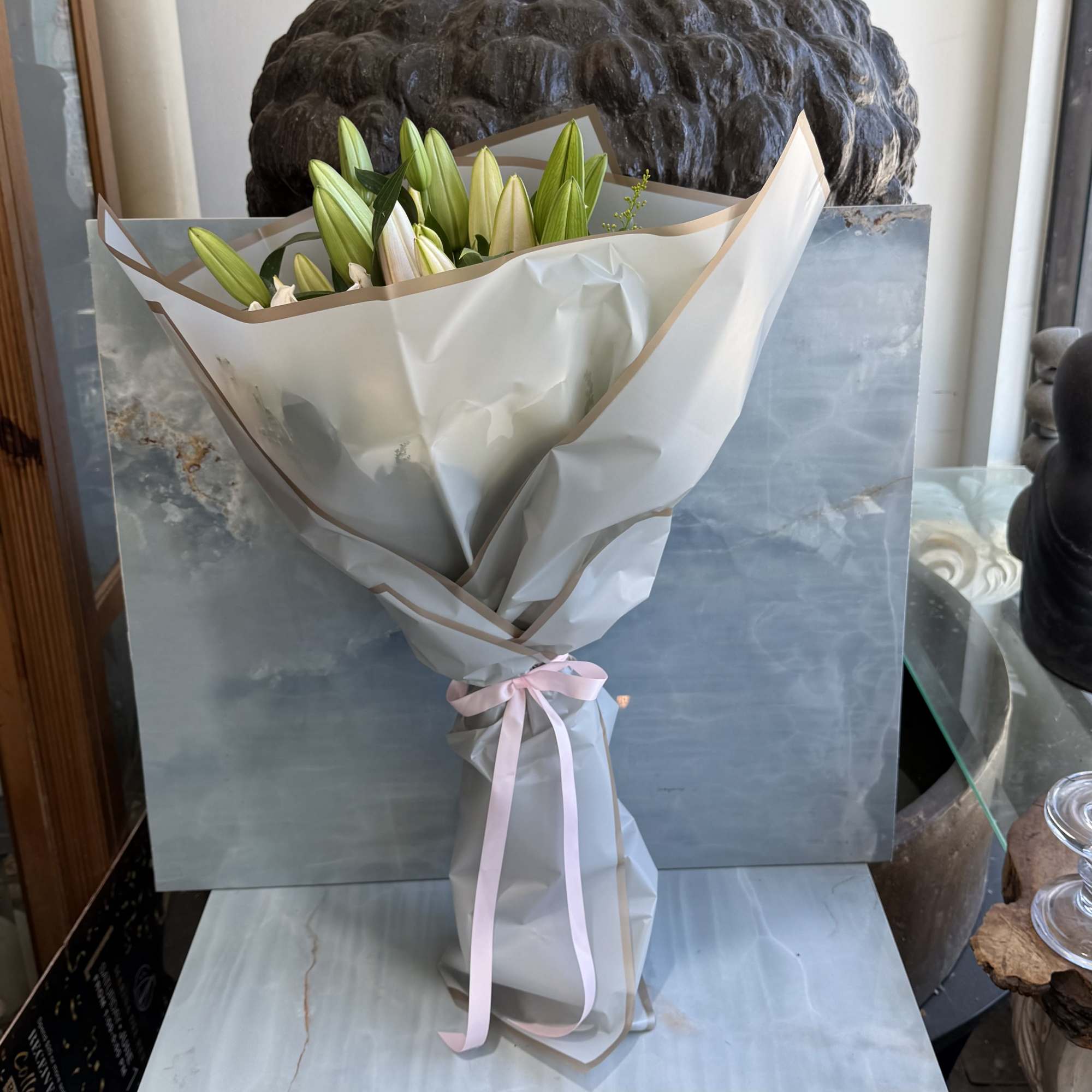 A graceful wrap bouquet featuring fragrant pink-and-white stargazer lilies surrounded by lush