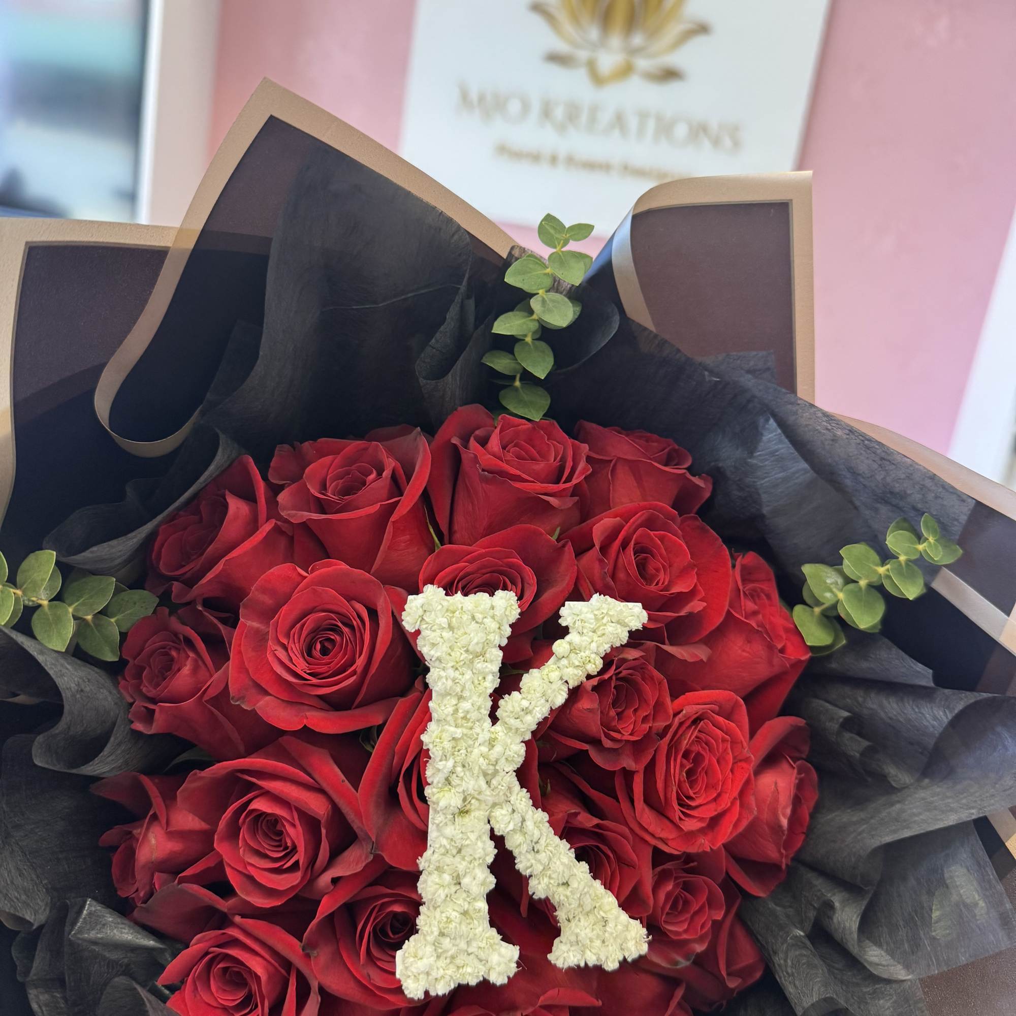Bouquet of red roses with a white floral letter K