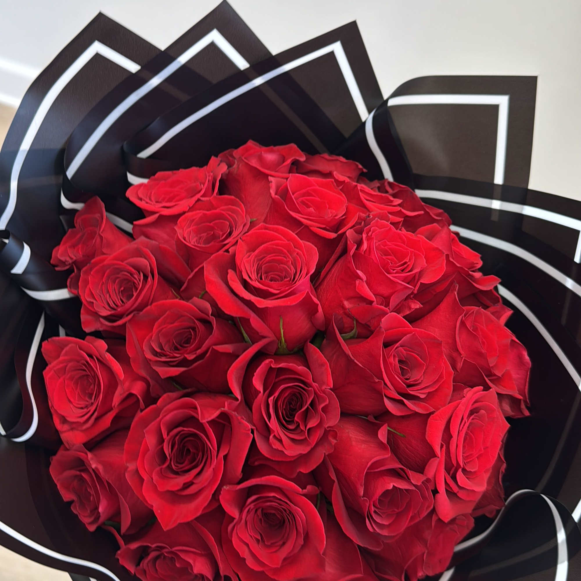 Bouquet of red roses wrapped in black paper