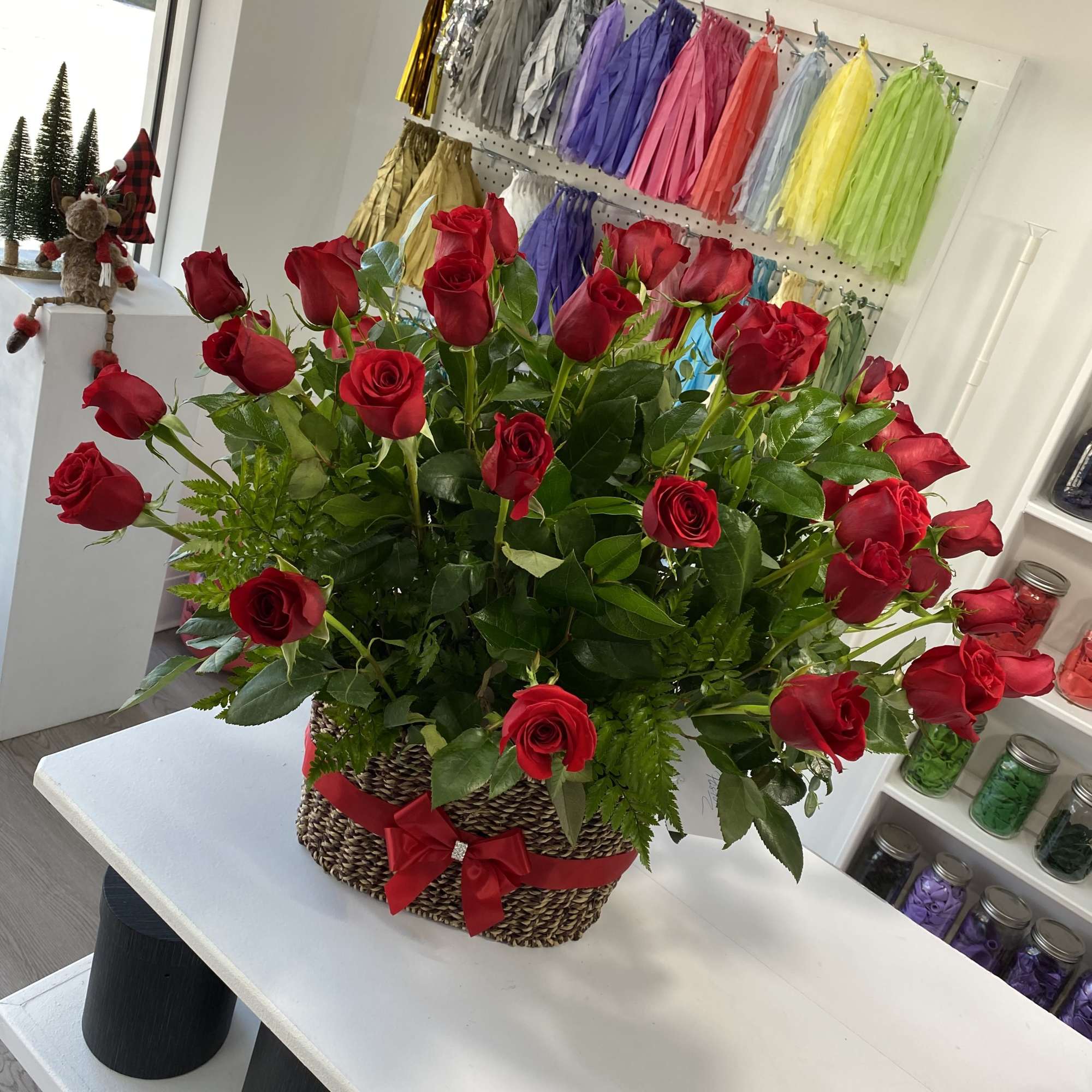 Basket arrangement of red roses with a red ribbon