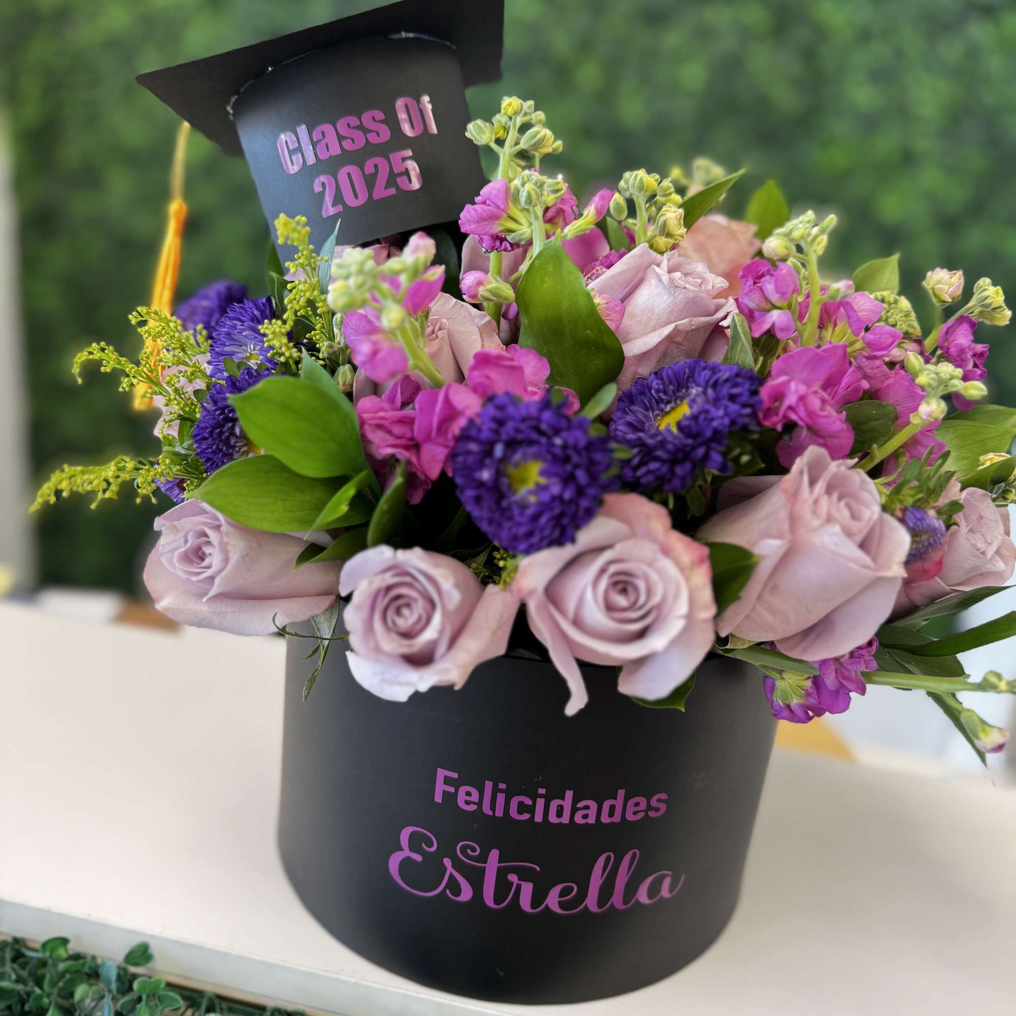 Graduation bouquet in a black box with pink and purple flowers