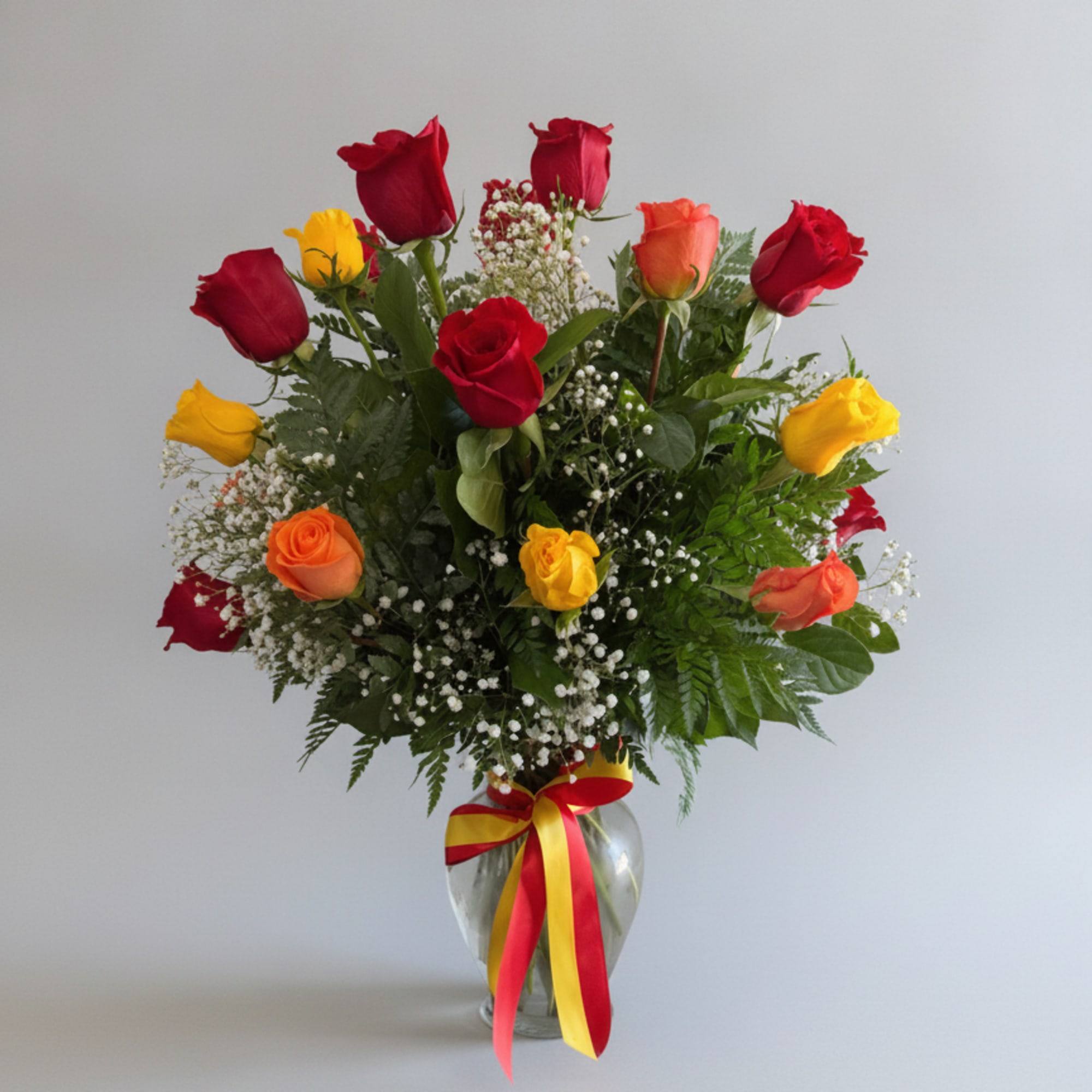 A blazing cluster of red, yellow, orange roses-tied with a cheerful red-and-yellow