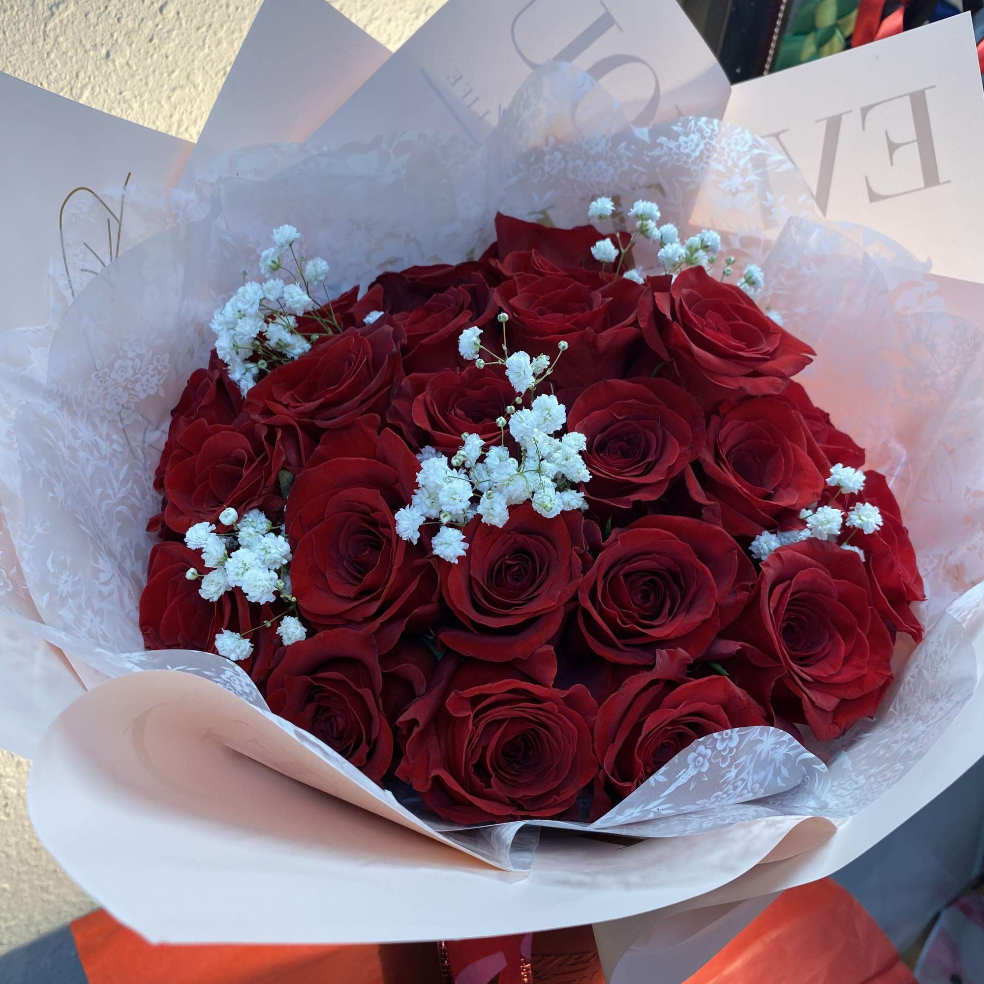 Bouquet of red roses with white baby's breath in white wrapping