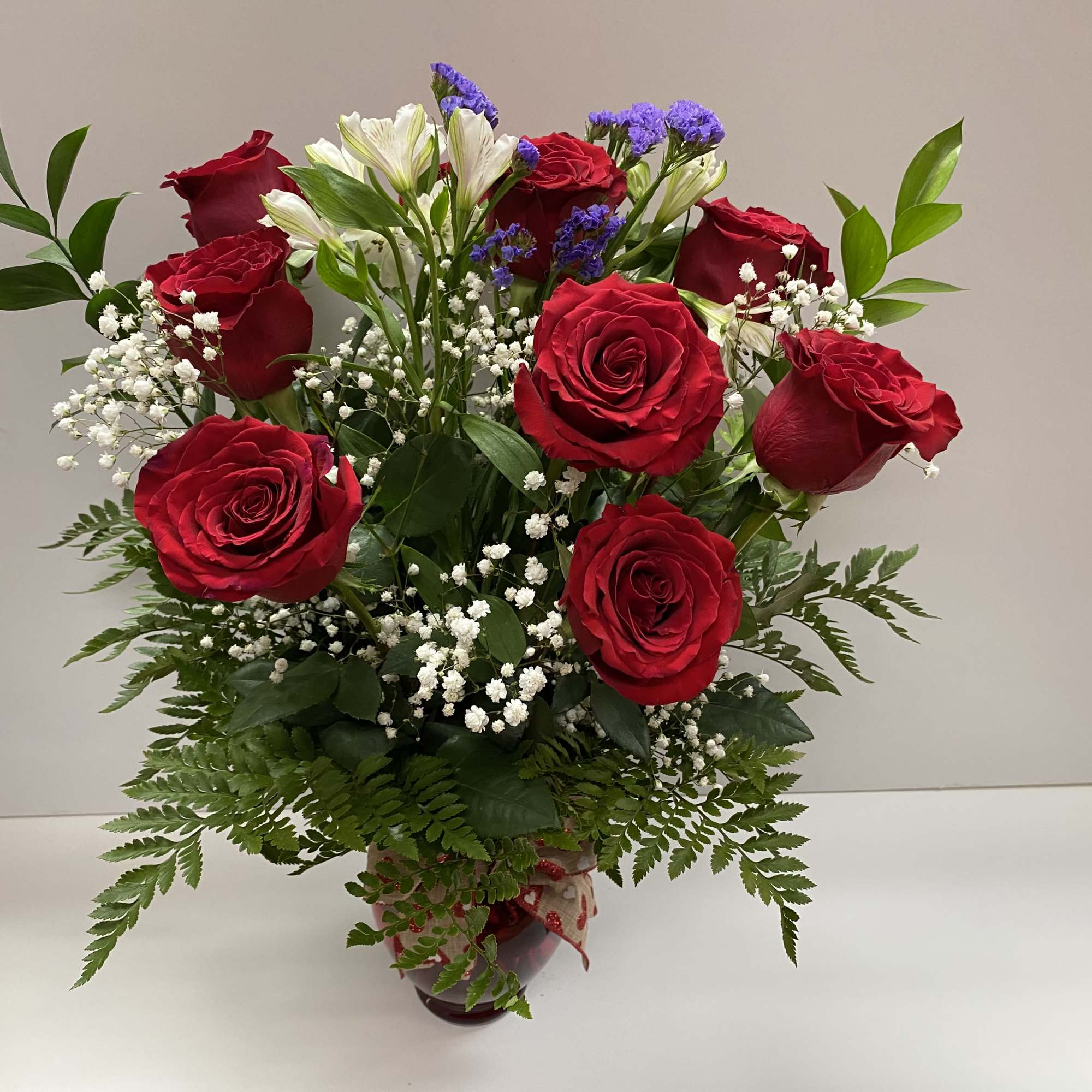 Bouquet of red roses, white alstroemeria, and baby's breath in a vase